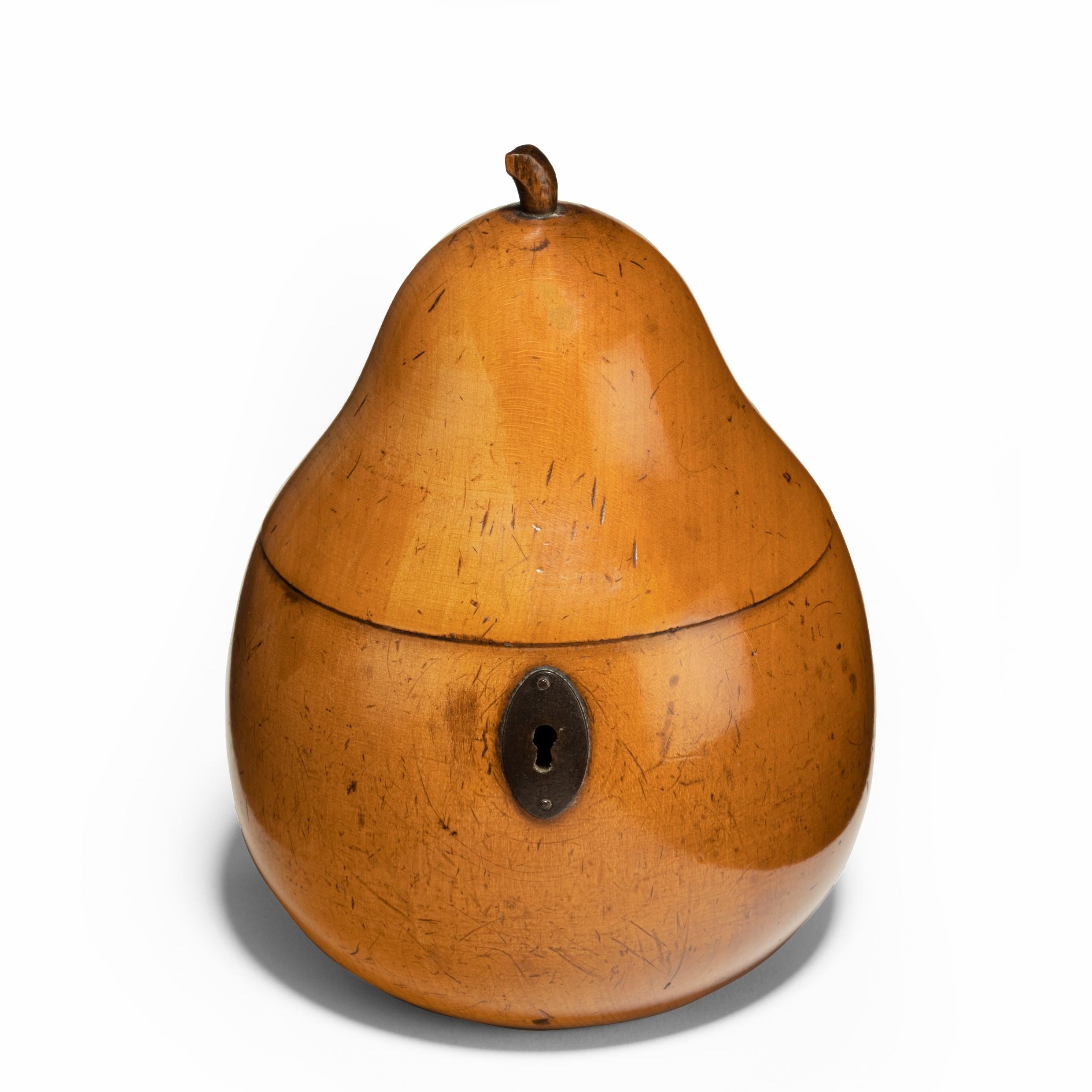 A fruitwood tea caddy in the form of a pear, with steel hinge and lock plate, the wood a sensational color, probably Continental, circa 1800.
 