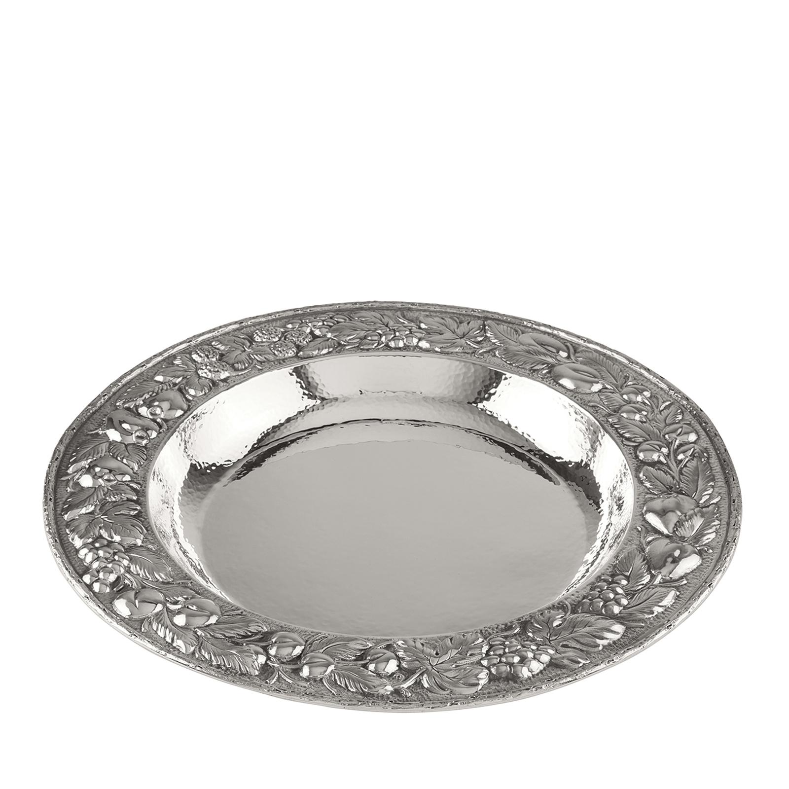 This elegant centrepiece is a deep dish entirely made in silver whose internal surface is textured with the Classic hammered surface, while the lip is intricately adorned with a magnificent chiselled decoration that depicts a garland of leaves,