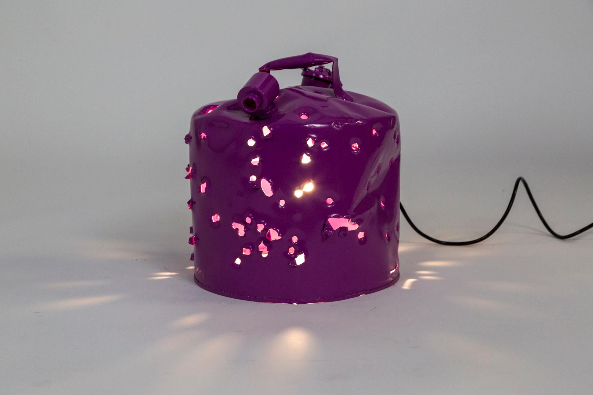 This antique metal gas can was shot with bullets, powder coated and wired as a lamp to become a bold work of art made Charles Linder. He has been making artwork out of bullet-riddled objects for over 30 years. The light coming through the holes has
