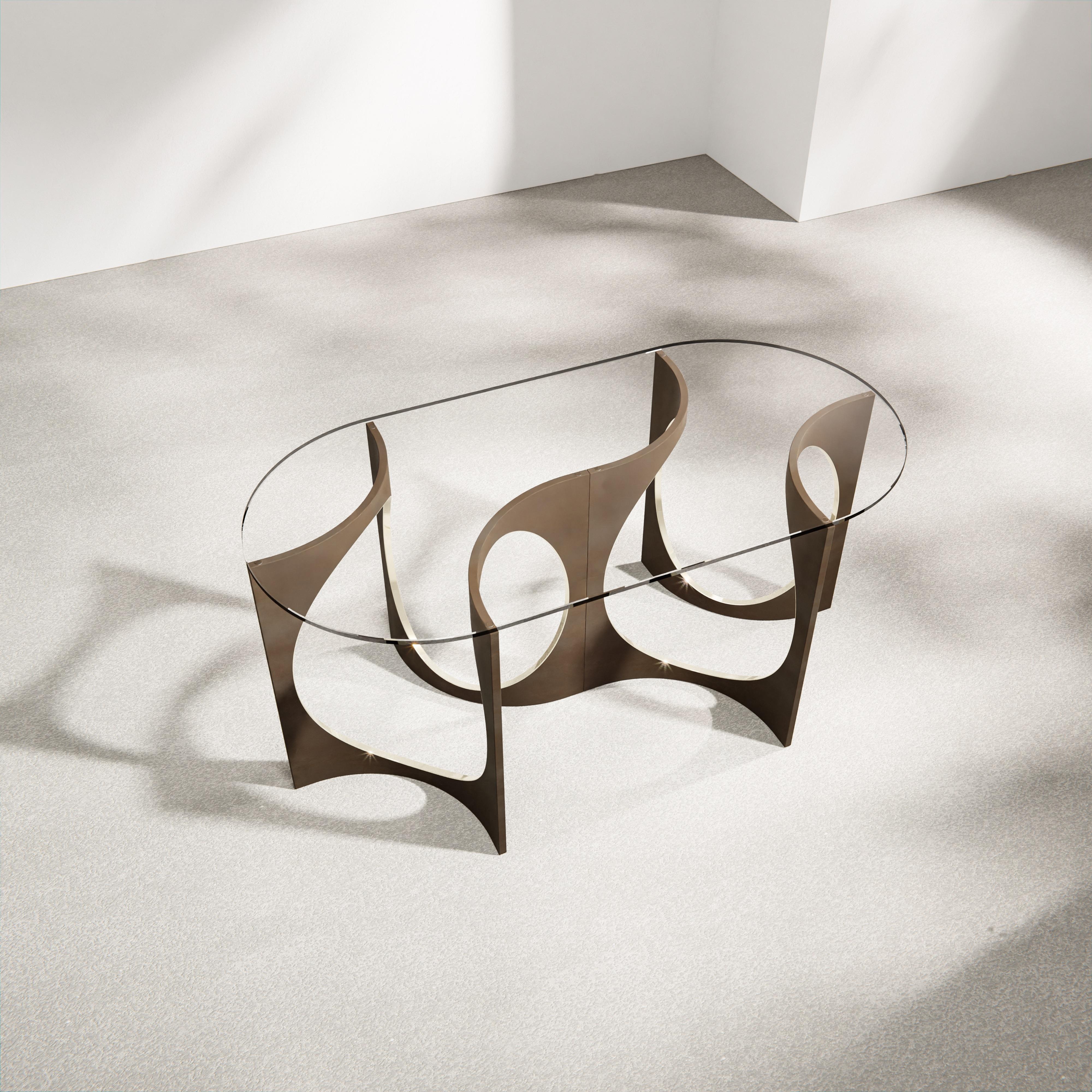 The Fuga table is a sculptural table with timeless elegance. Each base is handcrafted in Belgium from four identical solid cast bronze elements that are artistically welded into a continuous, organically shaped sculpture. The bronze is patinated and