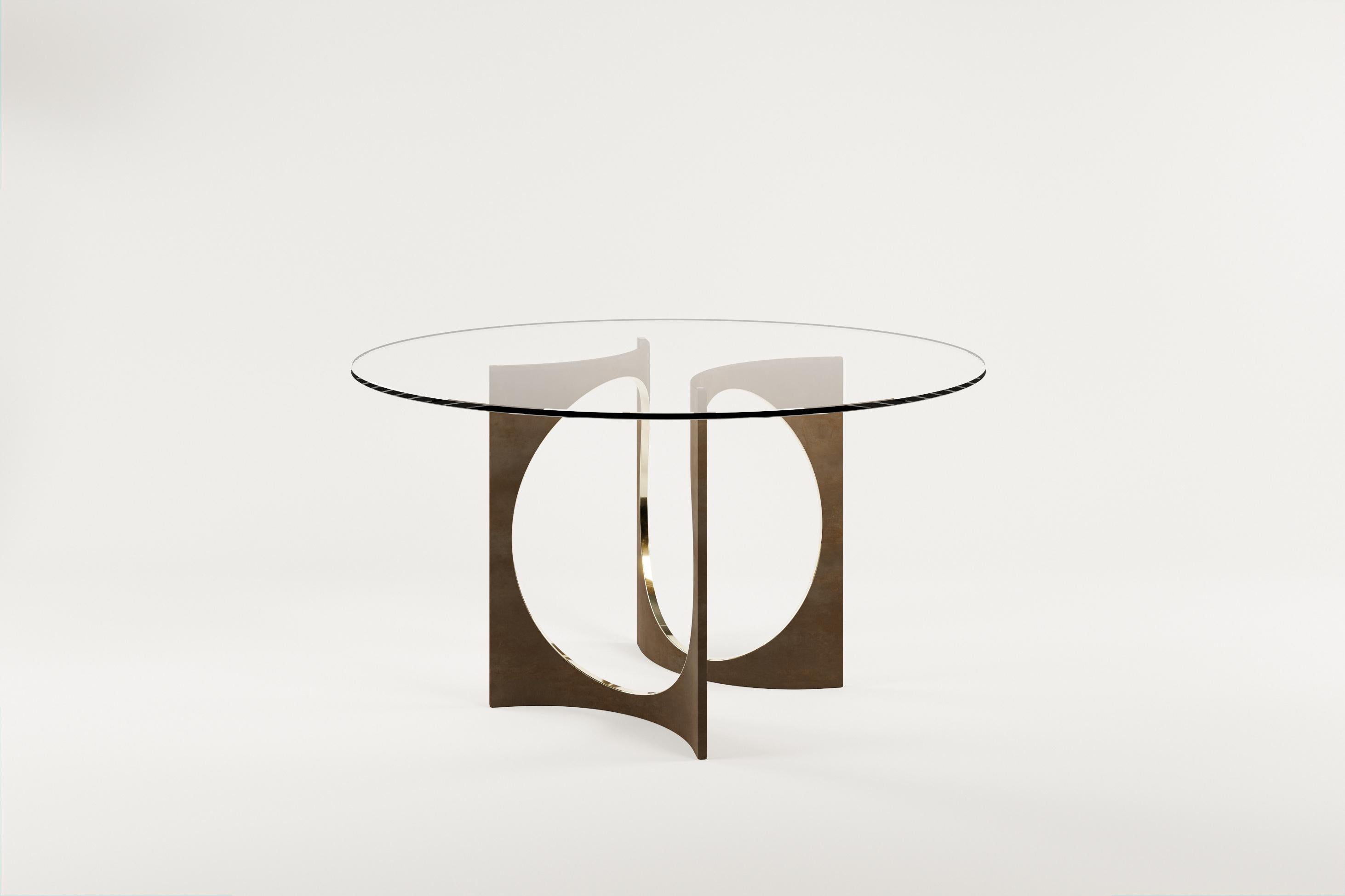 Mesa de comedor redonda Patina Fuga con tapa de cristal by Metamorphic Art Studio
Dimensiones: ⌀ 140 x H 76 cm
Materiales: Bronce fundido patinado, Vidrio

La mesa Fuga es una mesa escultural de elegancia atemporal. La base está hecha a mano en