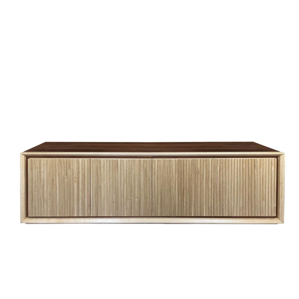 A creative combination of durmast and elegant dark walnut finishing details lends this sideboard its captivating chromatic contrast. A linear grooved design extends throughout the four doors, which open to reveal inner shelves where to neatly