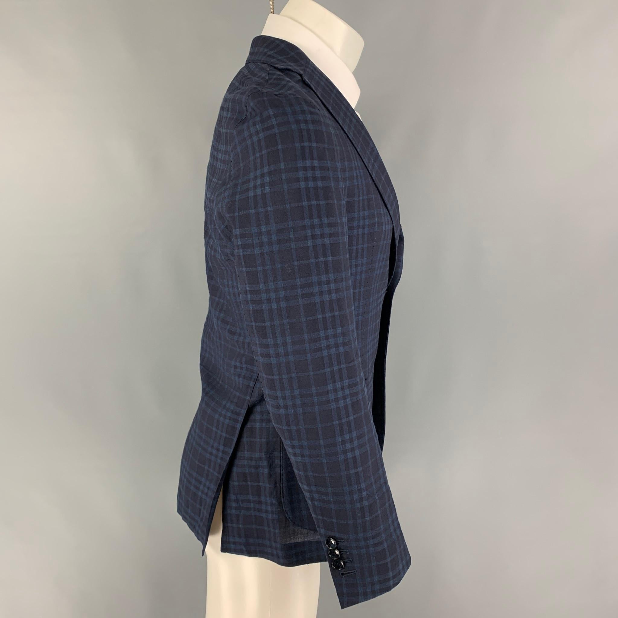 FUGATO for SHIPS sport coat comes in a navy & blue plaid flax / wool featuring a notch lapel, patch pockets, double back vent, and a three button closure. 

Very Good Pre-Owned Condition.
Marked: 46

Measurements:

Shoulder: 16.5 in.
Chest: 36