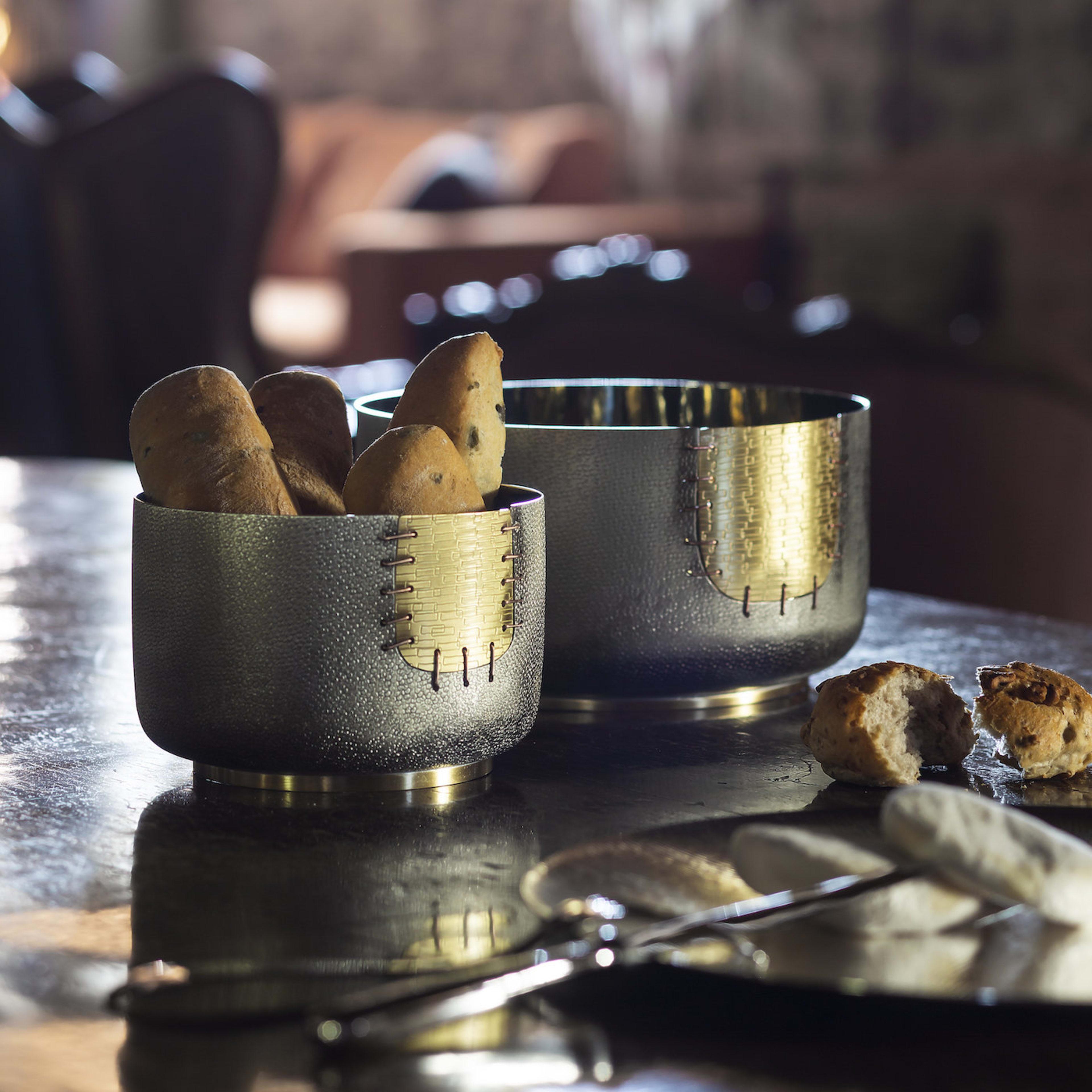 Este cuenco es un complemento versátil y llamativo para cualquier hogar moderno donde, tanto como jarrón como centro de mesa, causará sensación. Su sencilla silueta está adornada con un parche decorativo que parece haber sido cosido. Parte de una