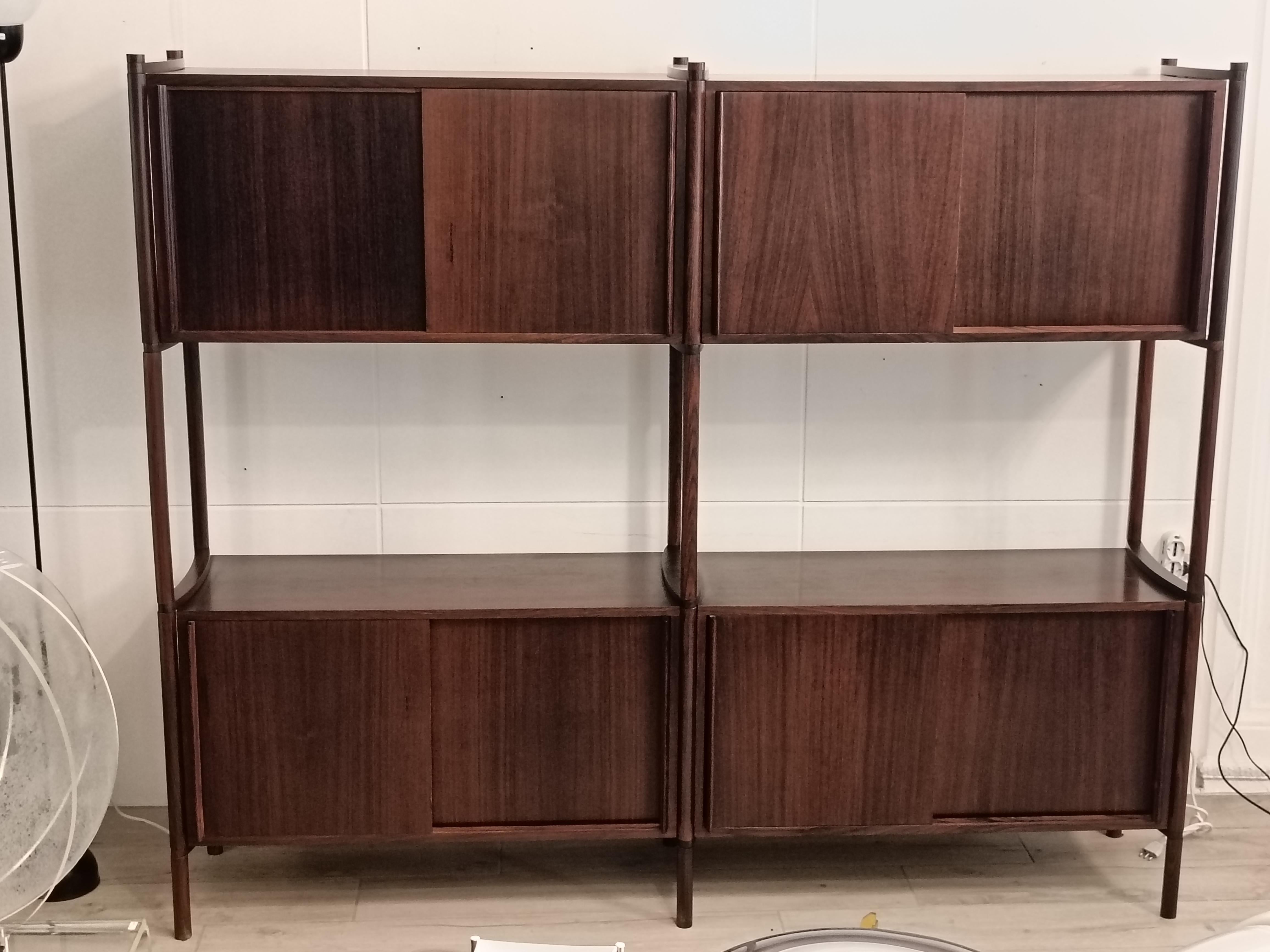 Aparador/librería modelo 'Archimede' diseñado a principios de los años 60 por Hirozi Fukuoh para Gavina. Fabricado a principios de los años 60 con maderas preciosas
Es un sistema de 2 módulos con otras tantas puertas correderas y piezas ensambladas,