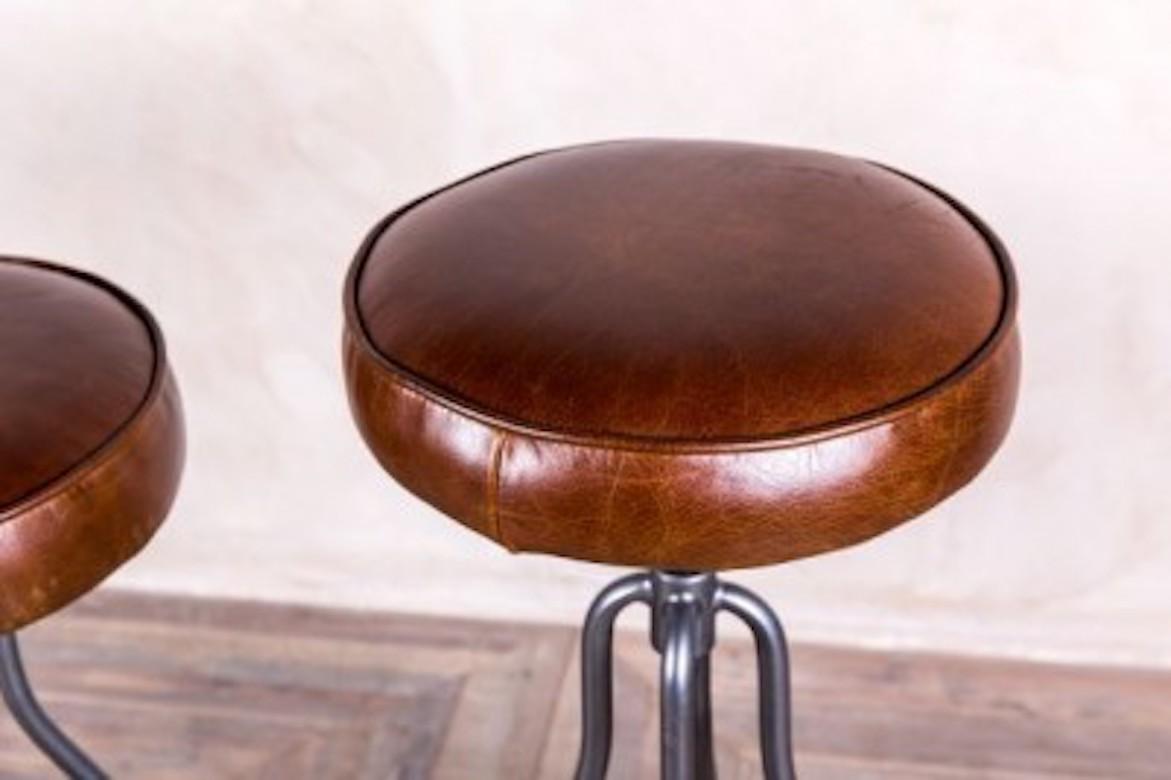 A fine Fulham height-adjustable leather stool, 20th century.

This adjustable leather stool is comfortable, durable and would look fantastic in both Industrial and vintage inspired interiors.

Its gunmetal colored tubular steel frame has a