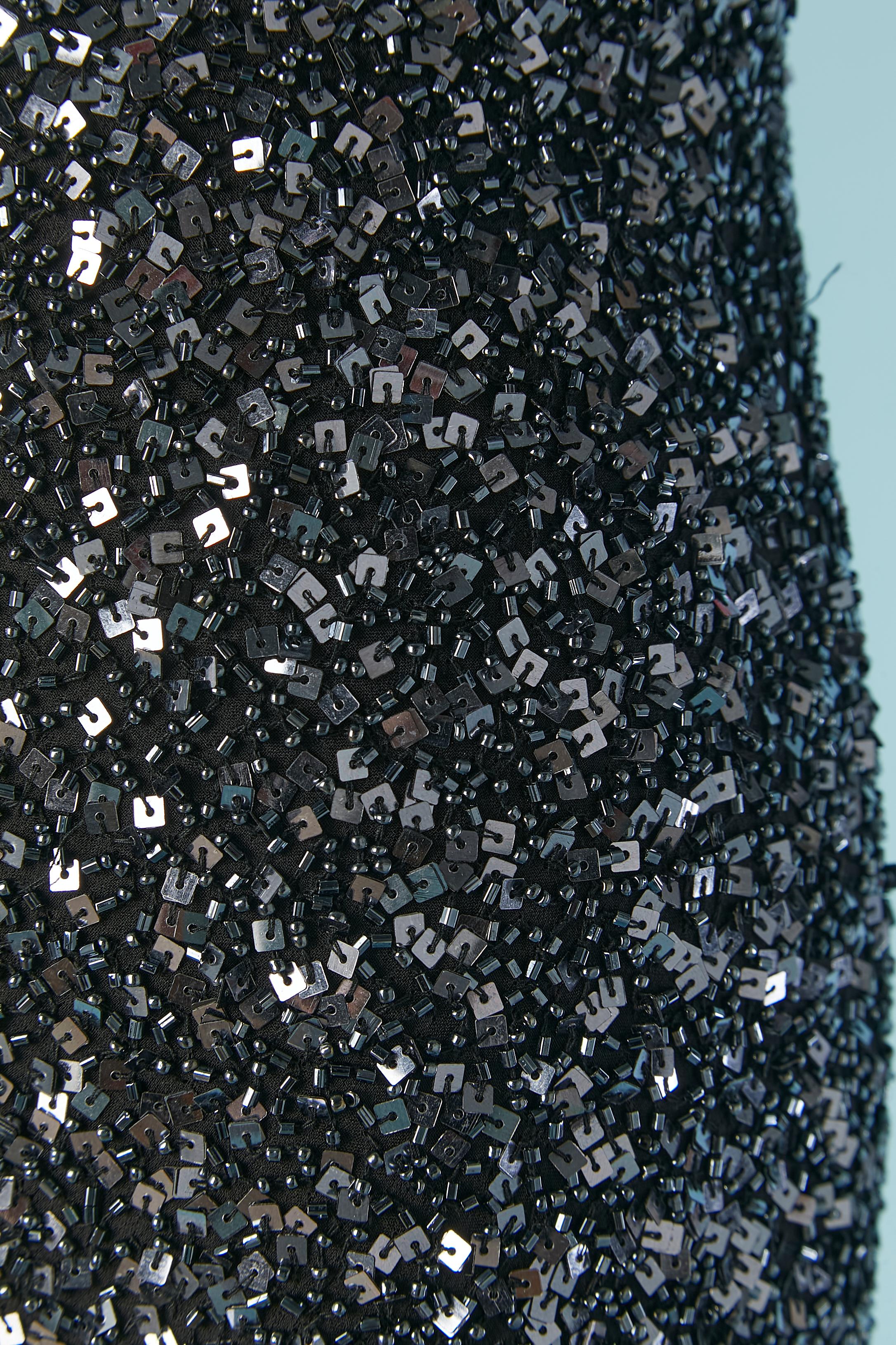 Robe de soirée bleu nuit entièrement perlée. Doublure en satin noir. Fermeture à glissière et crochet au milieu du dos. Cordon perlé à nouer au milieu du dos. 
TAILLE M 