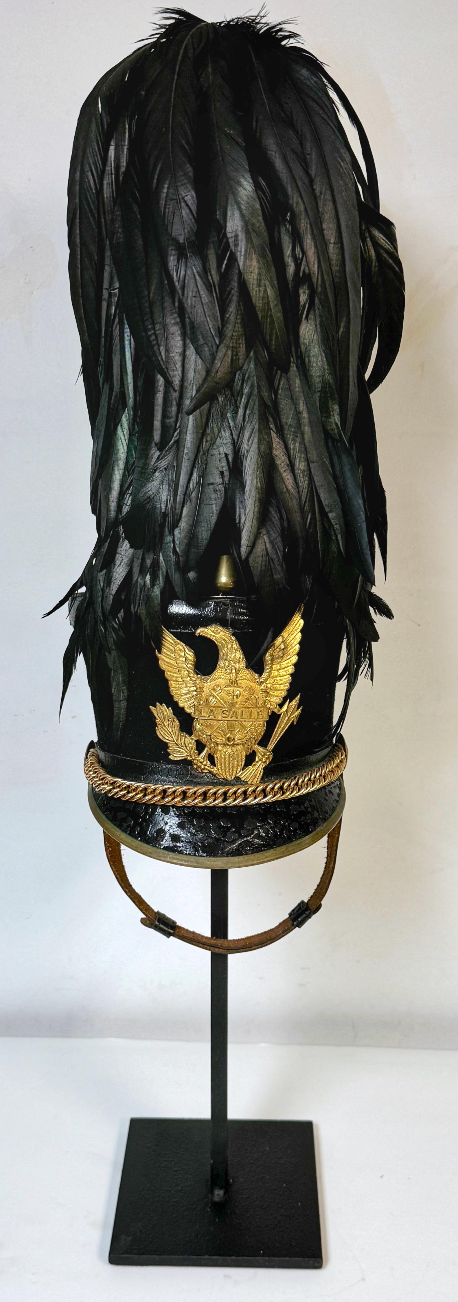 Full Dress La Salle Cadet ``Tar Bucket`` Dress Hat/Shako and Stand

USA, Late 19th Century/Early 20th Century 

This nearly pristine 'Tar Bucket' Dress Hat/Shako from the La Salle Military Academy is a striking piece of military history and