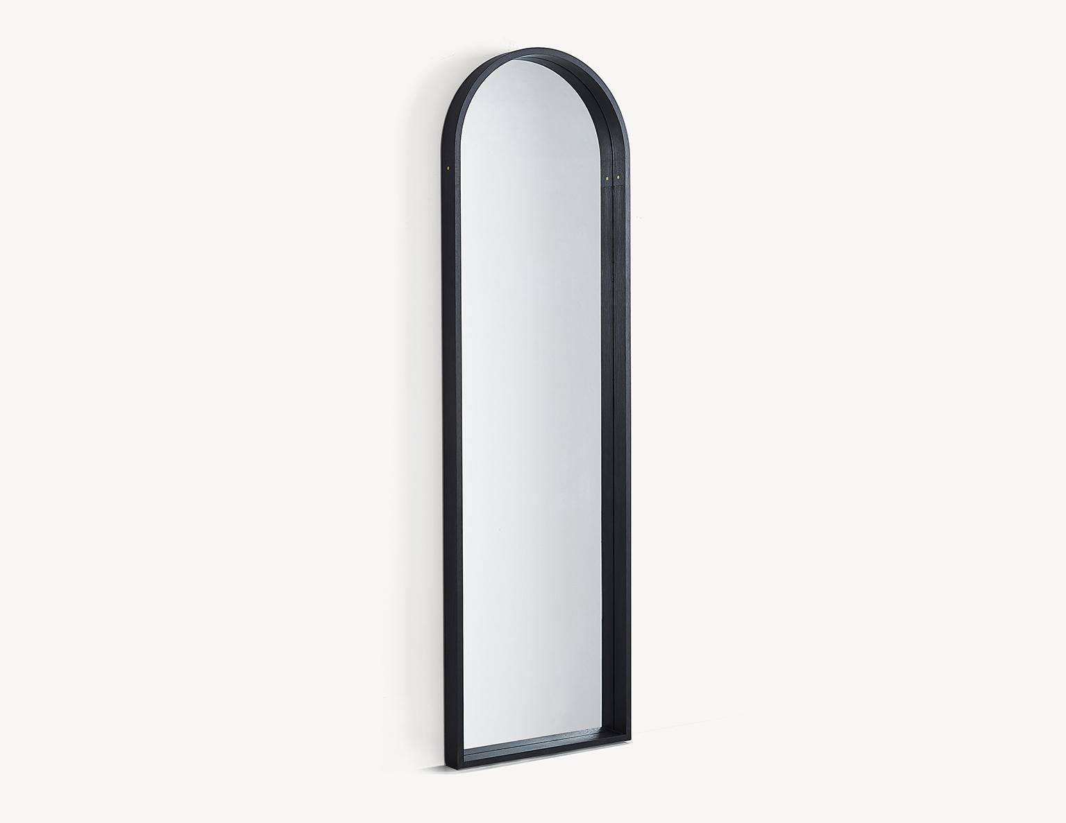 The contemporary Euclid mirror pays homage to the arched doorways that featured in Shaker architecture. The steam-bent arch is connected with brass pinned lap joints and the base of the frame features half-blind dovetails. The mirror floats off the