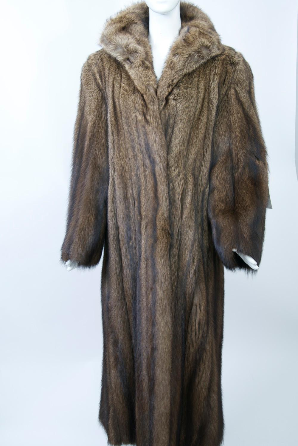 Fisher is considered one of the most luxurious furs. This full coat features a small spread collar that can be buttoned up at the neck, a straight cut, and strong shoulders. In addition to the button at the neck, there are fur hook closures down the