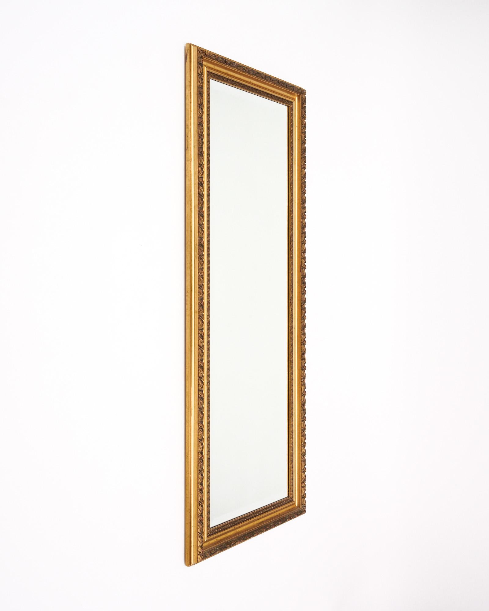 Spiegel aus der Art Déco-Periode in Frankreich, der im Stil Louis XVI hergestellt wurde. Dieses Stück hat einen handgeschnitzten Holzrahmen, der mit Blattgold versehen wurde. Der Rahmen zeigt ein florales Motiv. Der rechteckige Innenspiegel ist