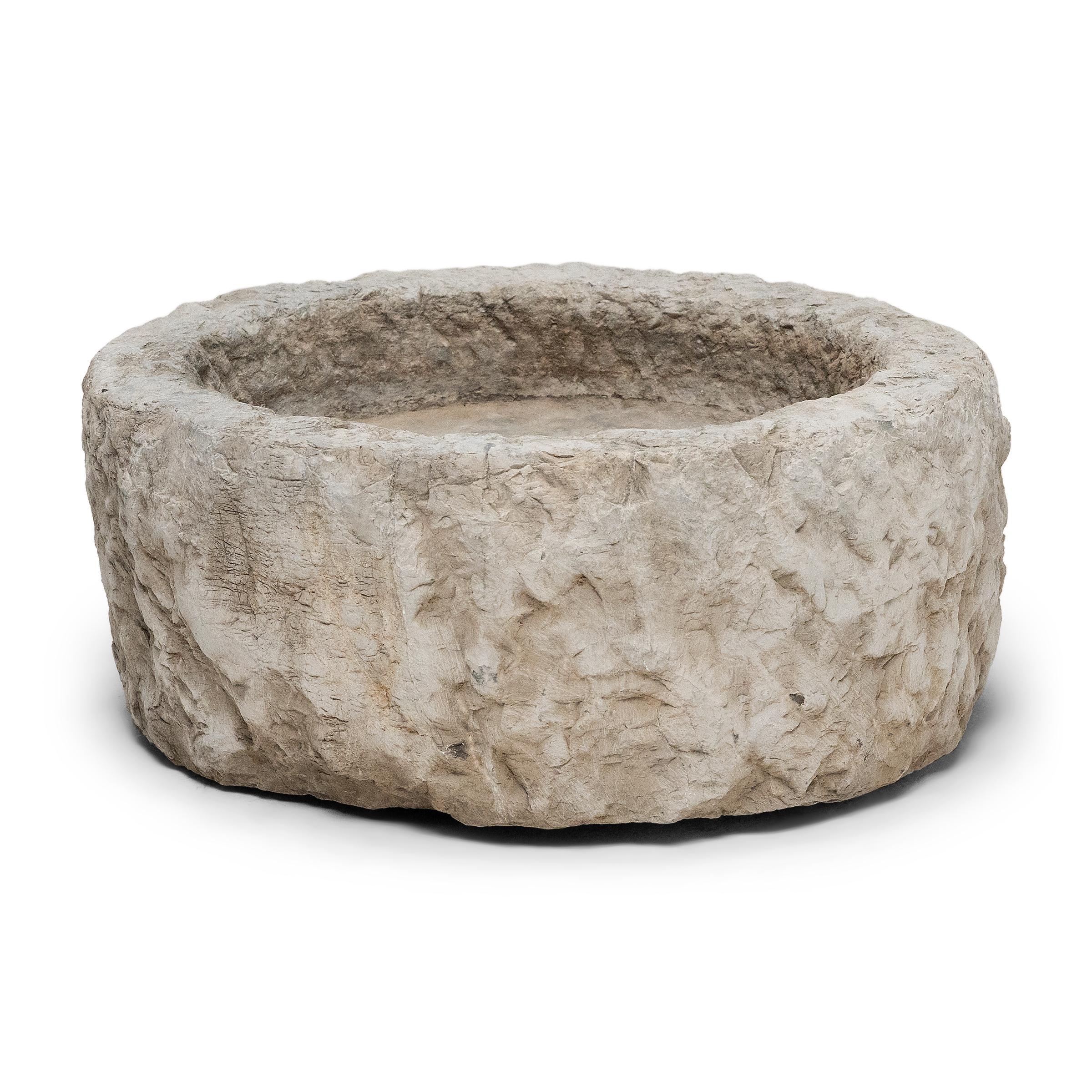 Once used on a provincial Chinese farm to hold water or animal feed, this early 19th-century stone trough is celebrated today for its organic form and rustic authenticity. Hand-carved from solid limestone, the trough has a circular form with slight