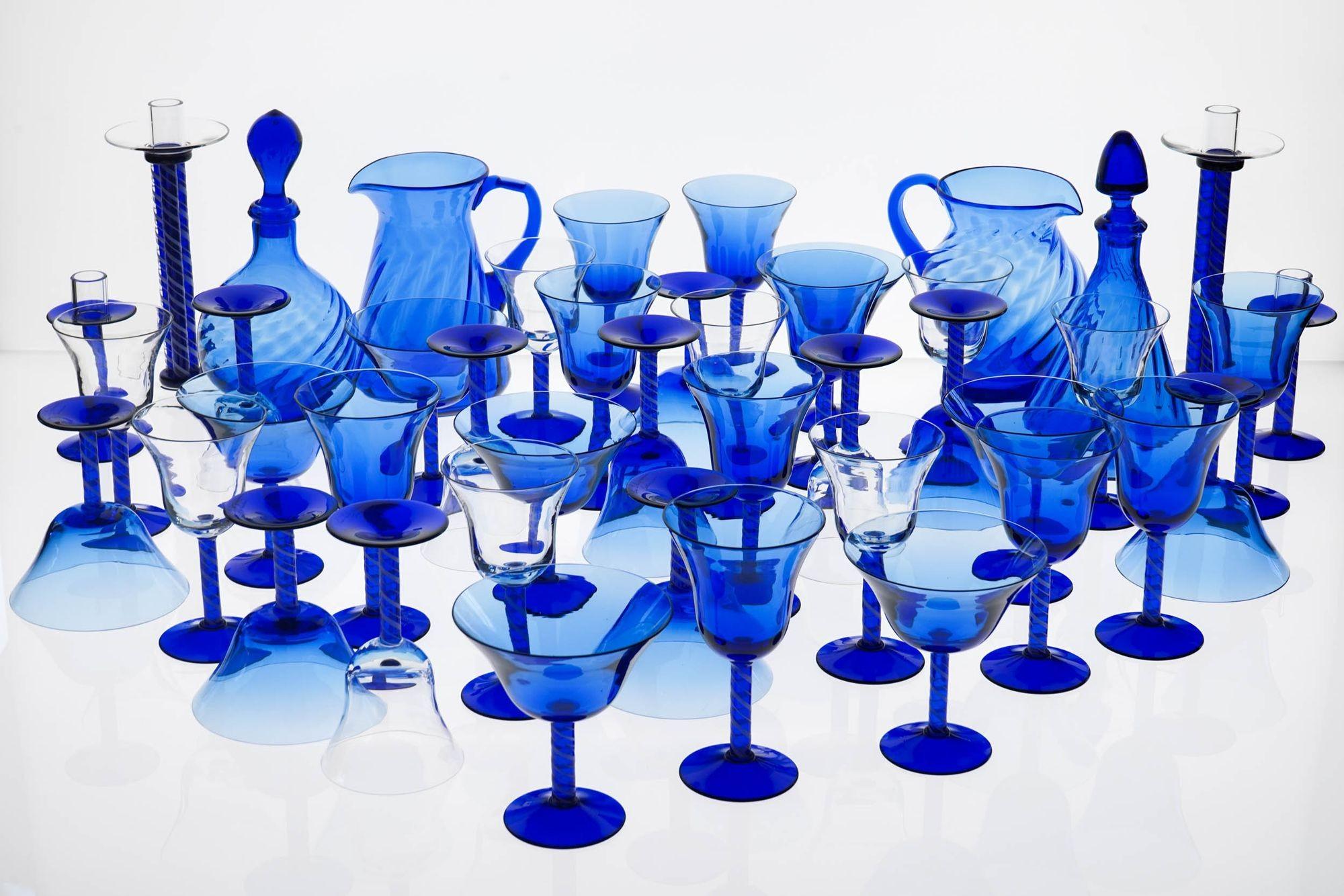 Complete Set of Cobalt Blue Murano Glass with White Zanfirico Striped Stems, signed La Filigrana Murano with some original packing.
This set includes 12 each of wine and water glasses, champagne cups (before the switch to flutes in the 80s), two
