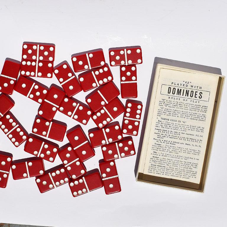 Complete set of red and white Bakelite dominoes. In original packaging this set is labeled “Marble Like Extra Thick Dominoes.”

Each domino is red with white accents. The original directions are also included. A great way to pass time on the patio