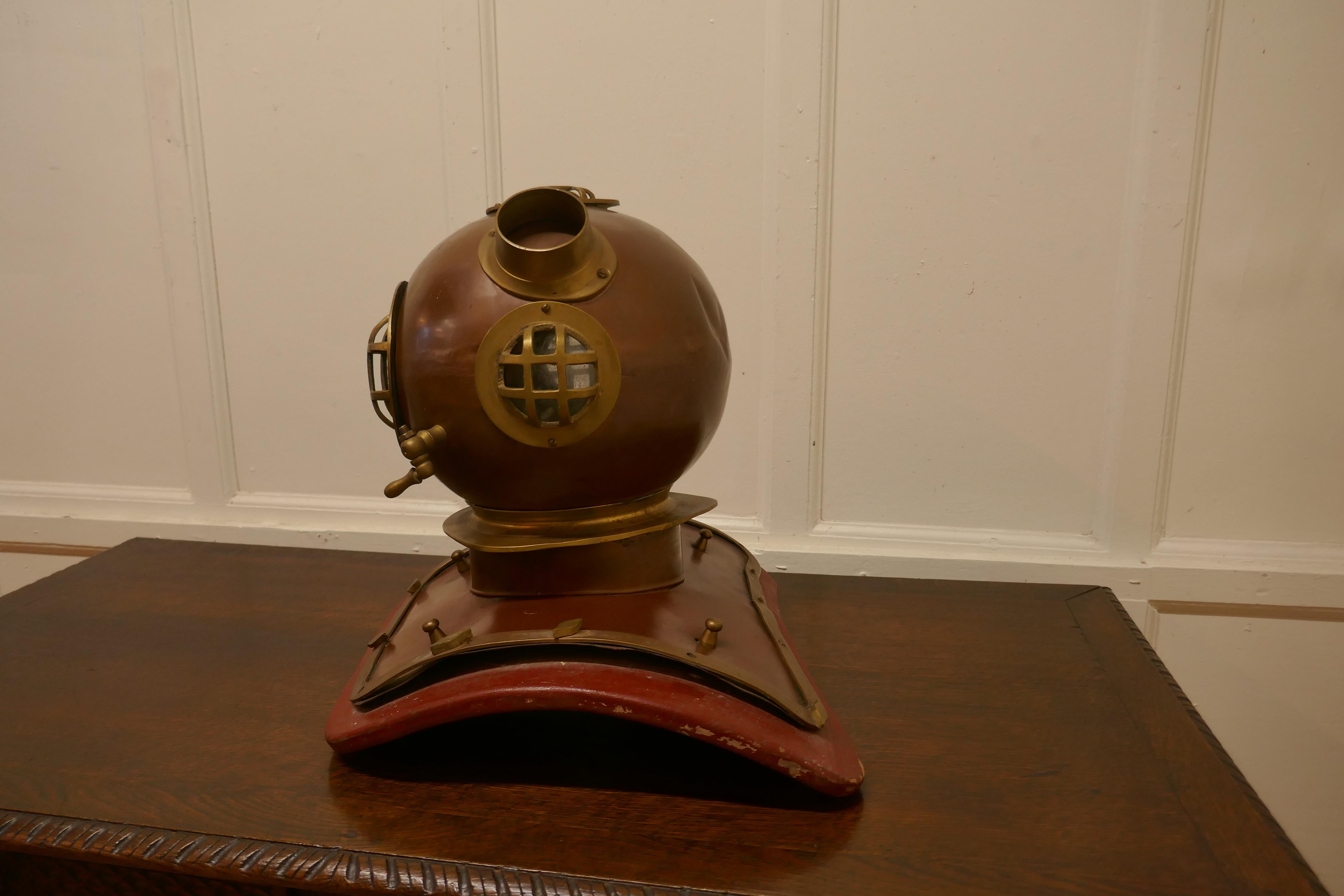Full Size 1950s Model Divers helmet, shop display piece 

The Helmet is a Rare Piece of Chandlery Shop Display, the helmet is a full size piece made in copper bronze and brass and set on a leather covered woodenshoulder shaped stand
In sound
