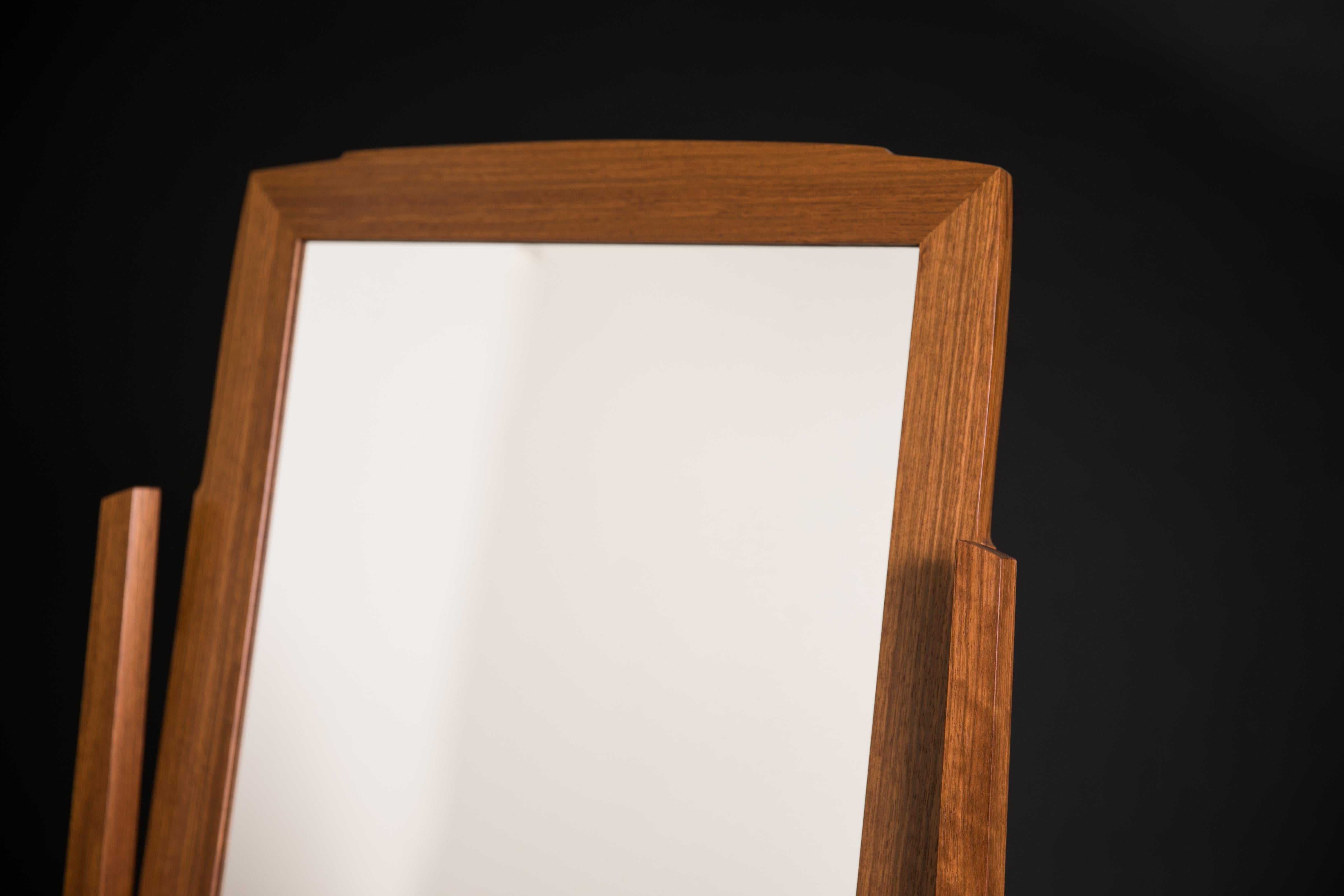 Während die traditionelle Form des Chevalspiegels oder Kippspiegels geehrt wird, spielt dieses Stück mit der Beziehung zwischen dem Rahmen und dem Spiegel selbst, indem es Kurven verwendet, die sich gegenseitig nachahmen. Der Stoff auf der Rückseite