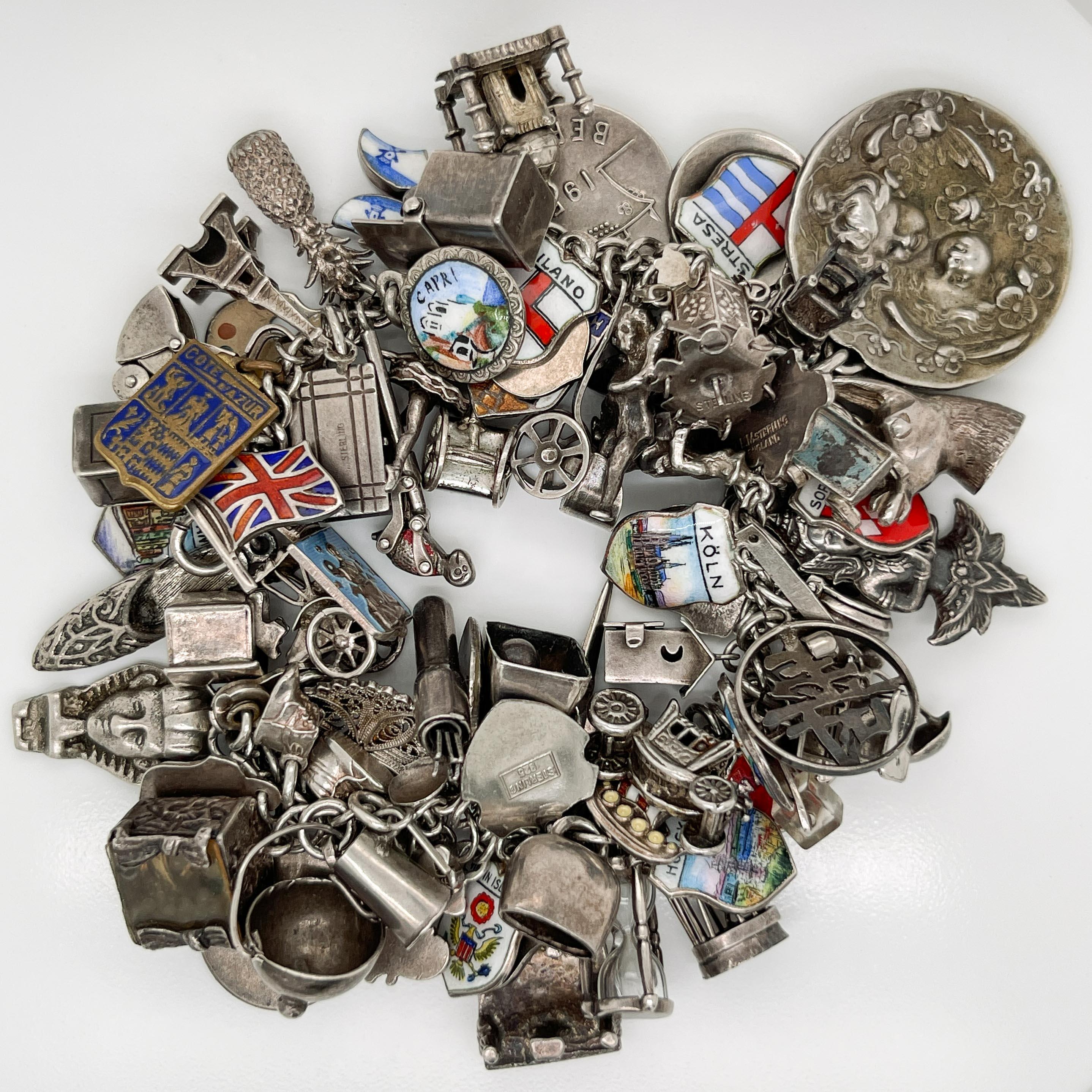 A fine, overflowing charm bracelet.

In sterling and 800 silver fineness.

With 70+ charms from around the world. 

Some of the rarest and most interesting charms include: a jack in the box, a diorama of person bathing, an out-house, an hourglass, a