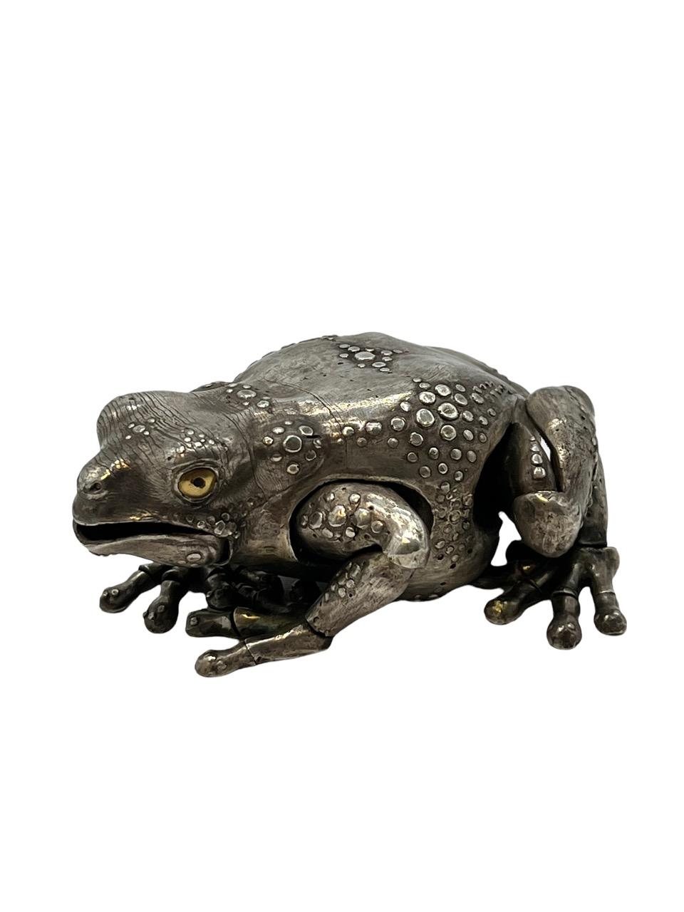 21st century fully articulated frog made of sterling silver by artist Oleg Konstantinov. It is realistically modeled with gold eyes and articulated legs, feet, toes, and mouth. 

