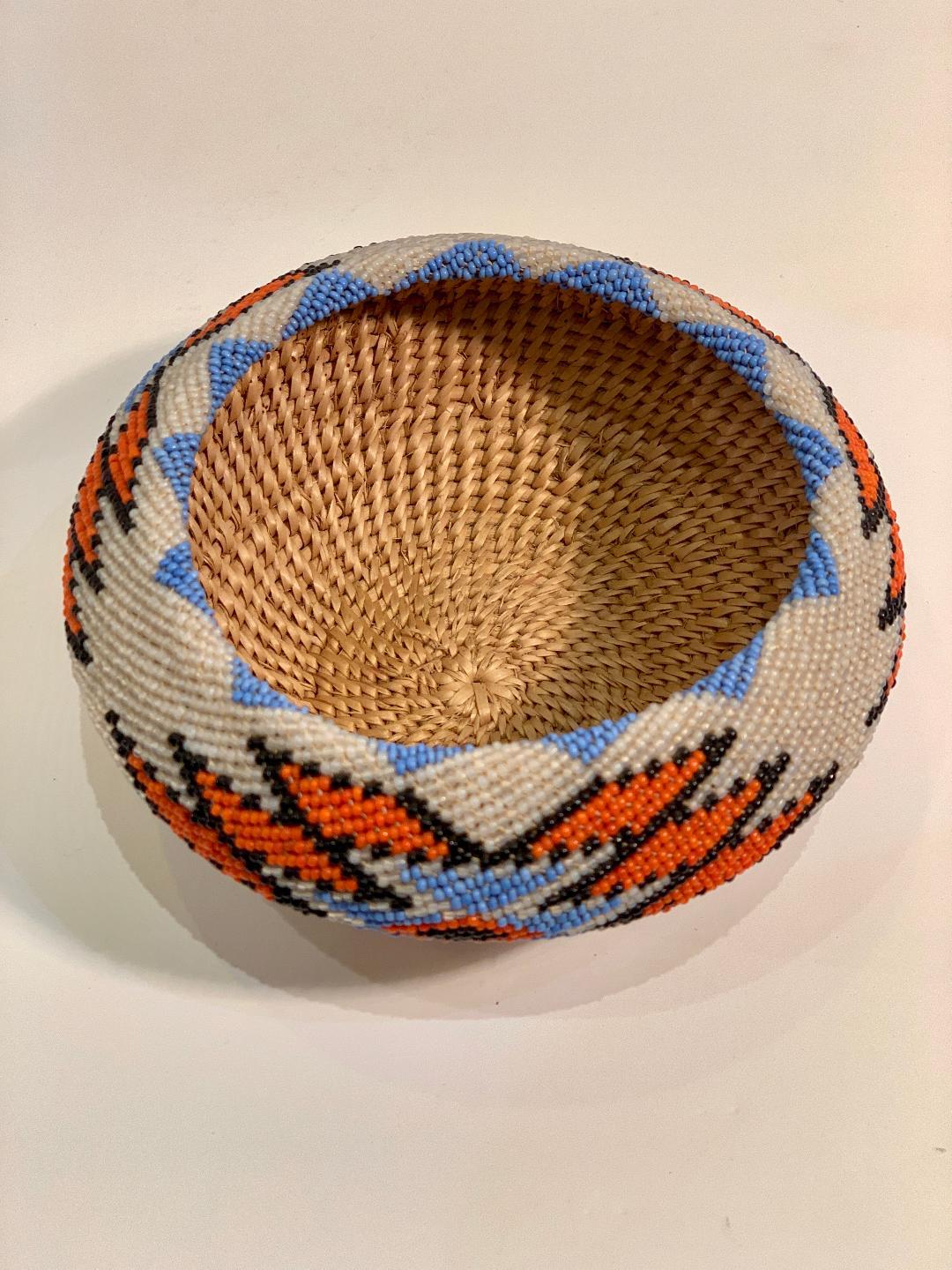 Very collectible, beautifully handmade Northern Paiute or Piute Native American Indian fully beaded basket features striking contrasting colors of orange, periwinkle and espresso (near black). Tightly woven weave basket coiled in willow with glass