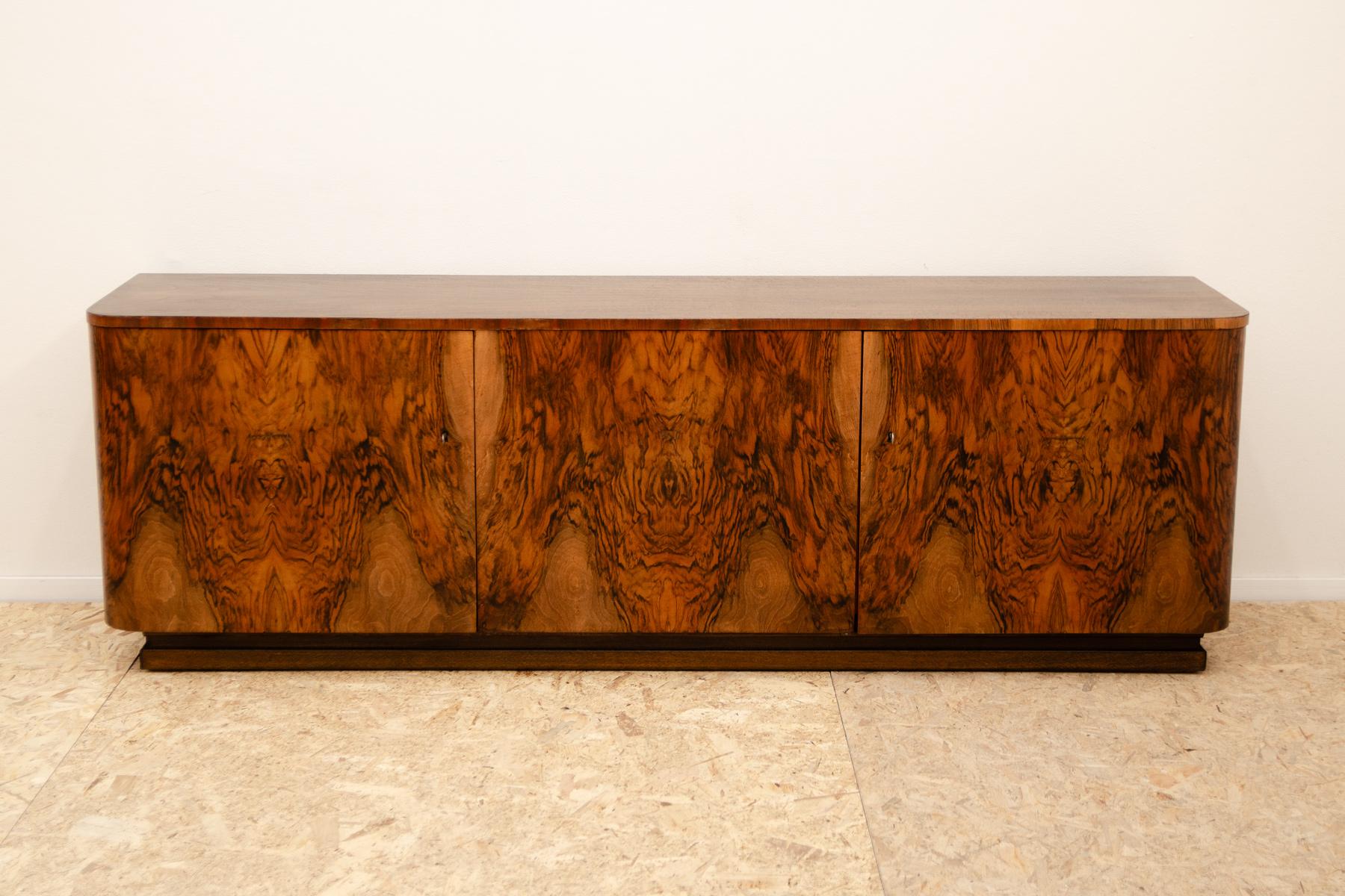 This huge ART DECO sideboard was made in the former Czechoslovakia in the 1930s.
The piece has a beautiful rounded shapes, solid wooden plinth on the bottom.
It is made of walnut wood and veneered with a beautiful walnut veneer.
It’s an example of