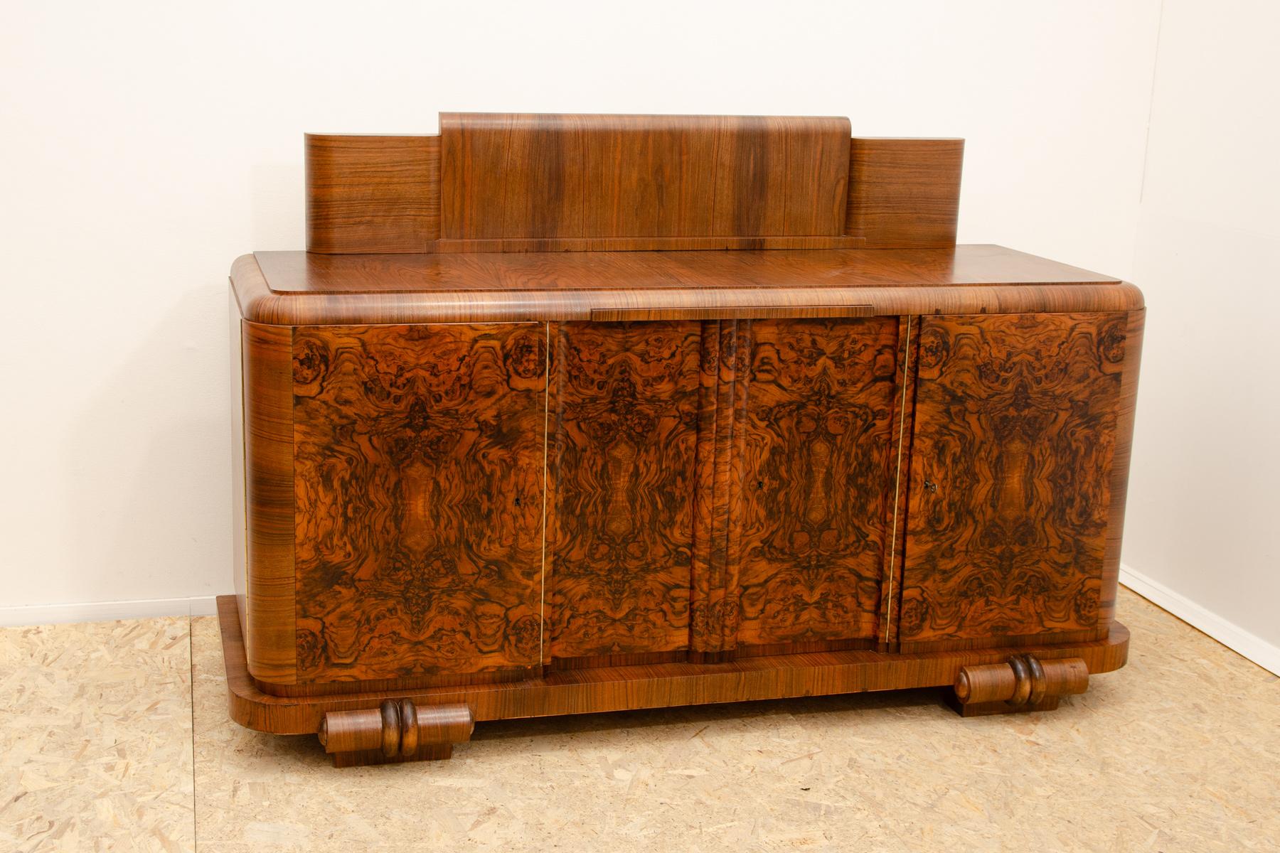 Esta pieza de estilo ART DECO se fabricó en la antigua Checoslovaquia en la década de 1930.

Es de madera maciza chapada en nogal.  Puedes utilizar el mueble como barra o como aparador.  Sobre la placa superior se coloca un panel de apoyo, que es