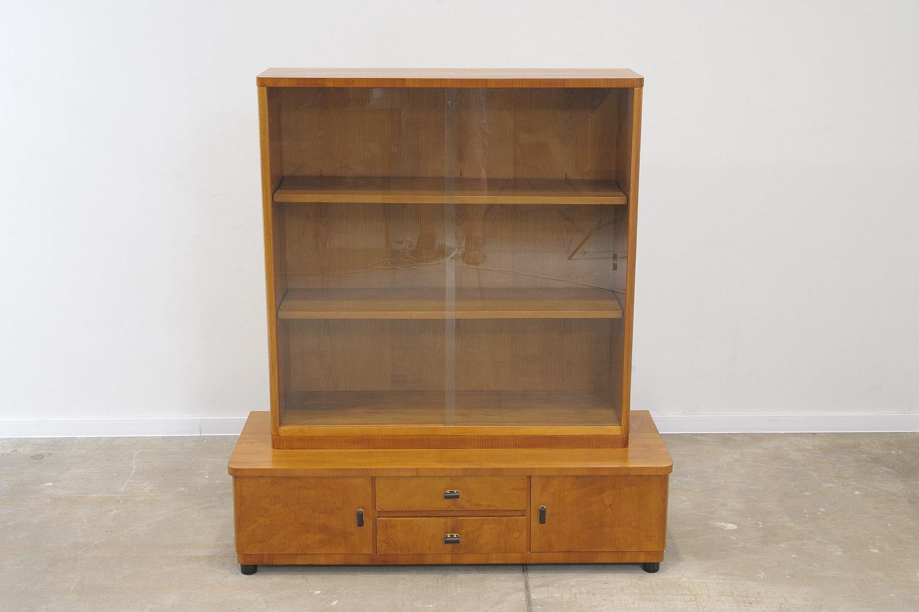 This bookcase was made in the former Czechoslovakia in the 1930´s.

the library consists of two parts that can be separated from each other. Upper glazed and lower with storage areas.
The library is quite easy to handle.

It features a regular