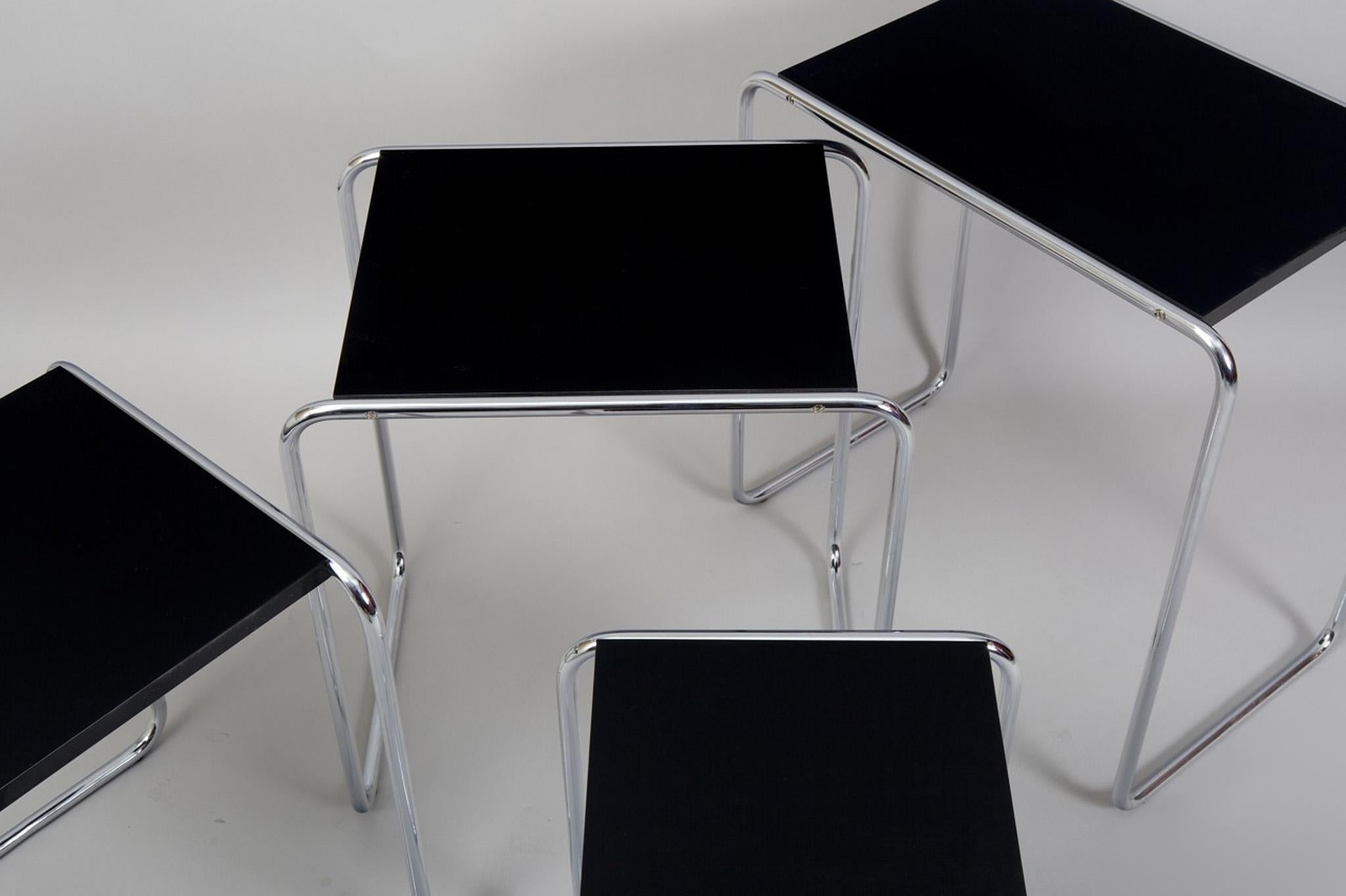 Beautiful black nest tables made in the 1950s, they are made out of lacquered wood and chrome plated steel. 
Made by Kovona

Dimensions of the biggest piece: 
Height: 59 cm (23.23 in)
Width: 56,5 cm (22.24 in)
Depth: 37 cm (14.57 in).
 