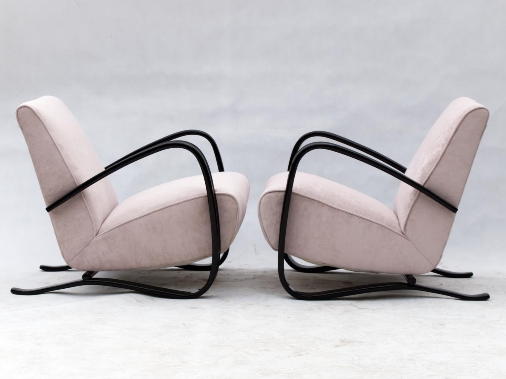 Fully restored pair of iconic H-269 lounge chairs designed by Jjindrich Halabala for UP Závody Brno in light pink fabric, with black lacquered arms.