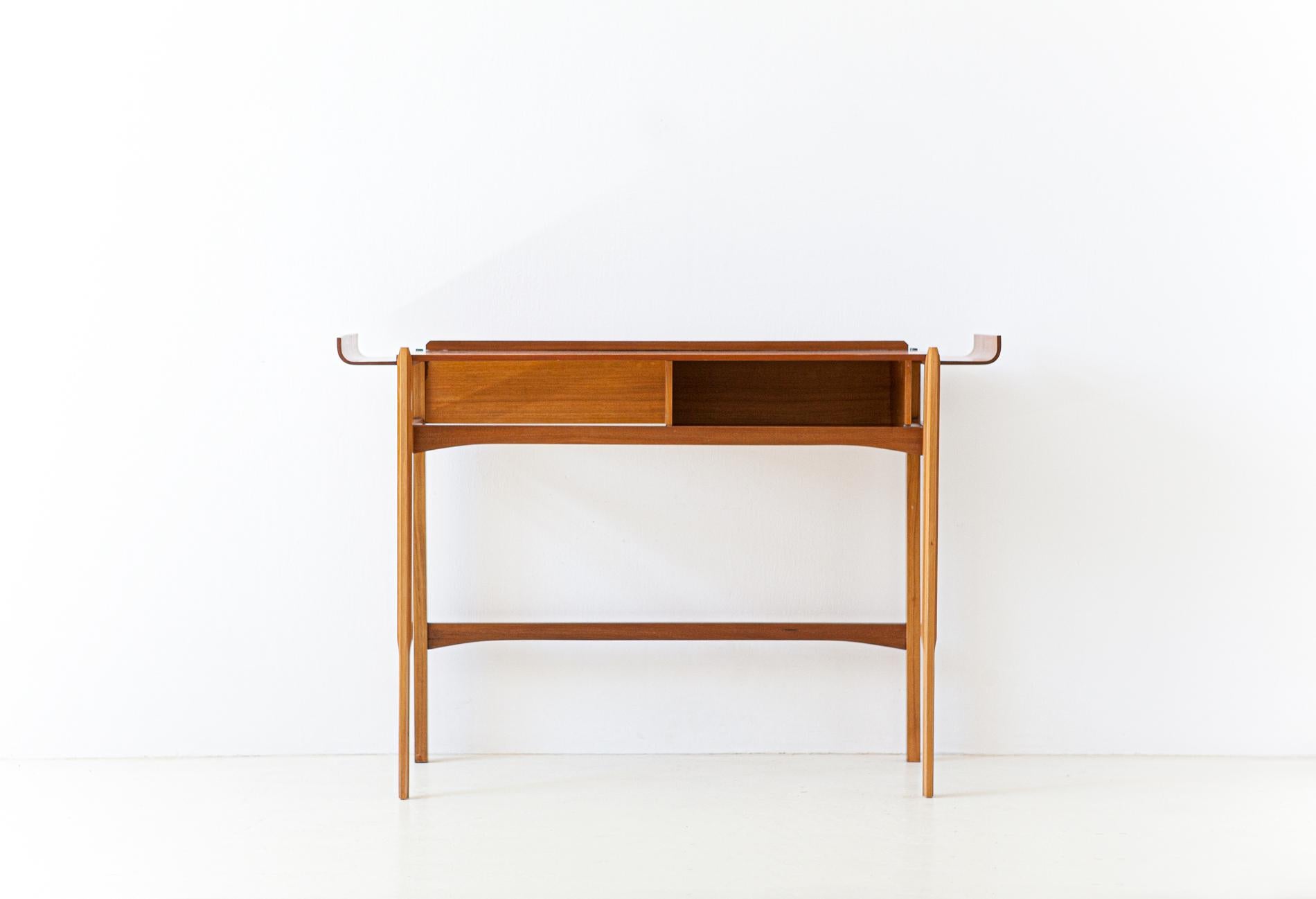 A wooden console, manufactured in Italy during the 1950s.
Teak wood with curved parts, this entry table can also be used as a side table or as a small desk for laptop.
Completely restored.
 
