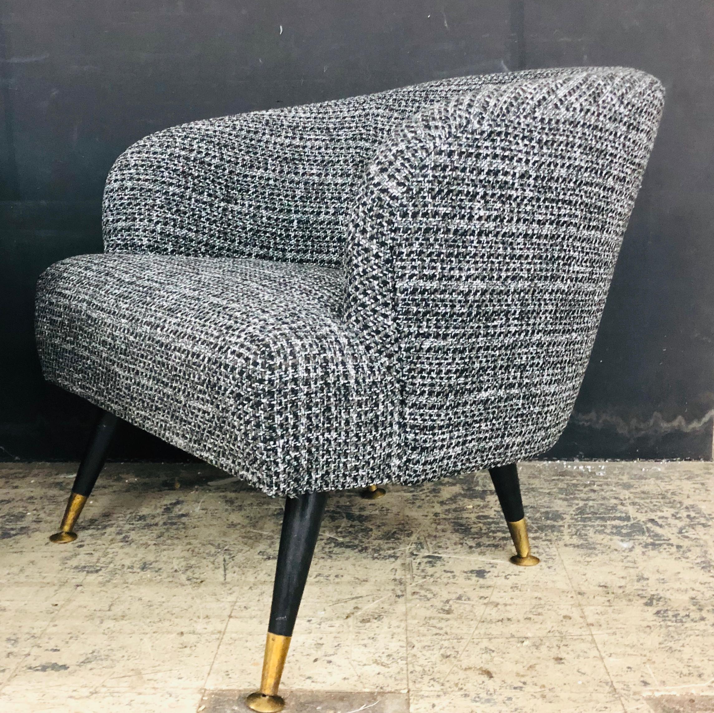 Fully restored Mid-Century Modern barrel backed club chairs. The feet are original with self-leveling sabots. The fabric is a rich, loosely woven blend of black, white and gray.