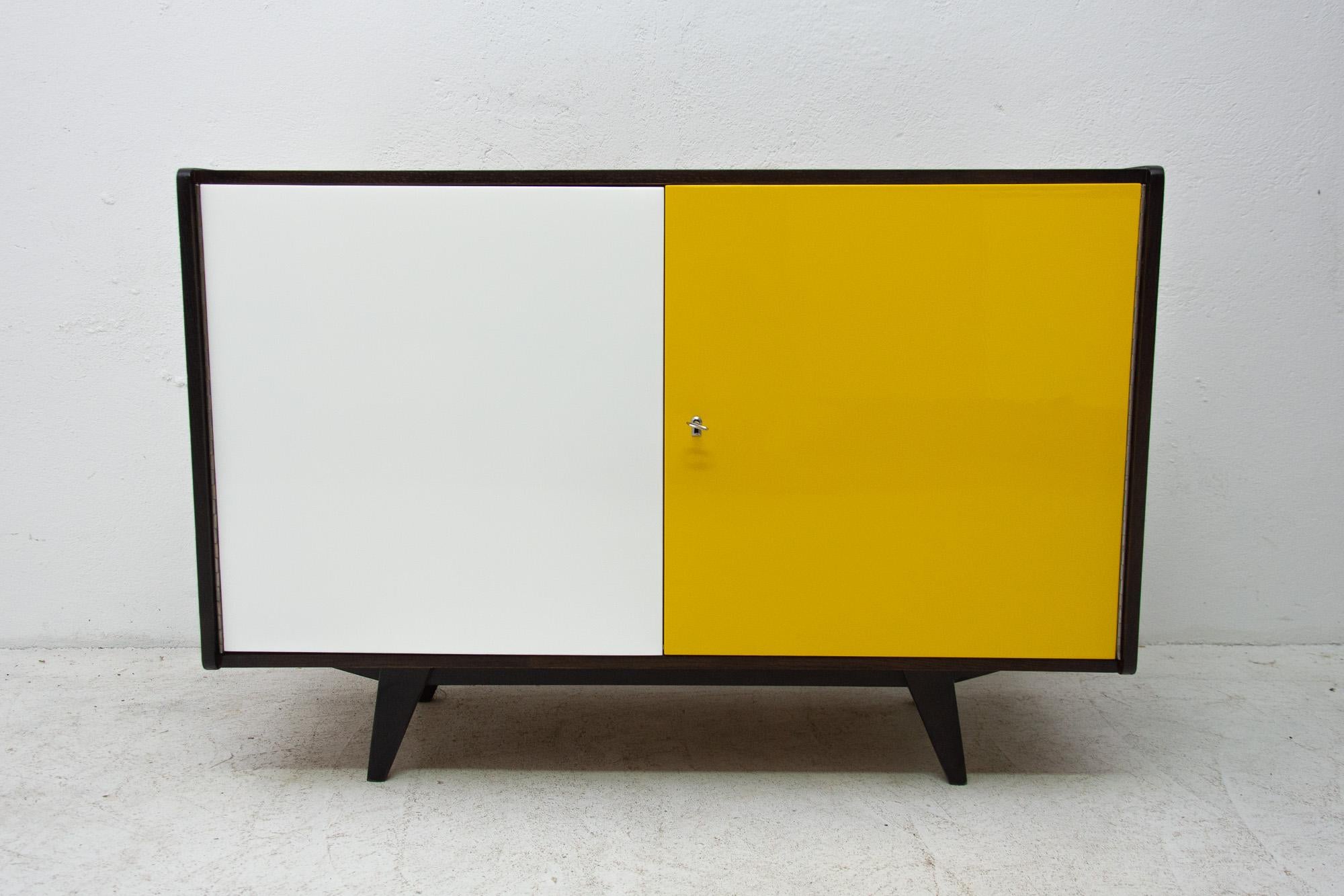 Midcentury sideboard-cabinet, catalogue No. U-450, designed by Jiri Jiroutek. It´s made of beechwood, veneer, plywood and laminate. In excellent condition, fully refurbished. Dark stained surface, mahogany inside.

The cabinet comes from the