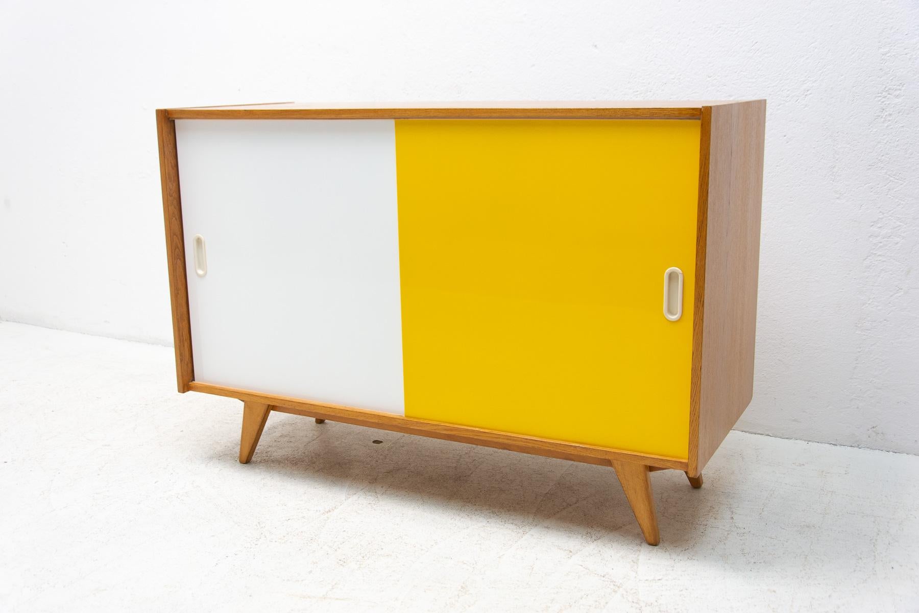 Mid-century sideboard-cabinet with sliding doors, catalogue No. U-452, designed by Jiri Jiroutek. It's made of beechwood, veneer, plywood and laminate. In excellent condition, fully refurbished.

The cabinet comes from the famous Universal series
