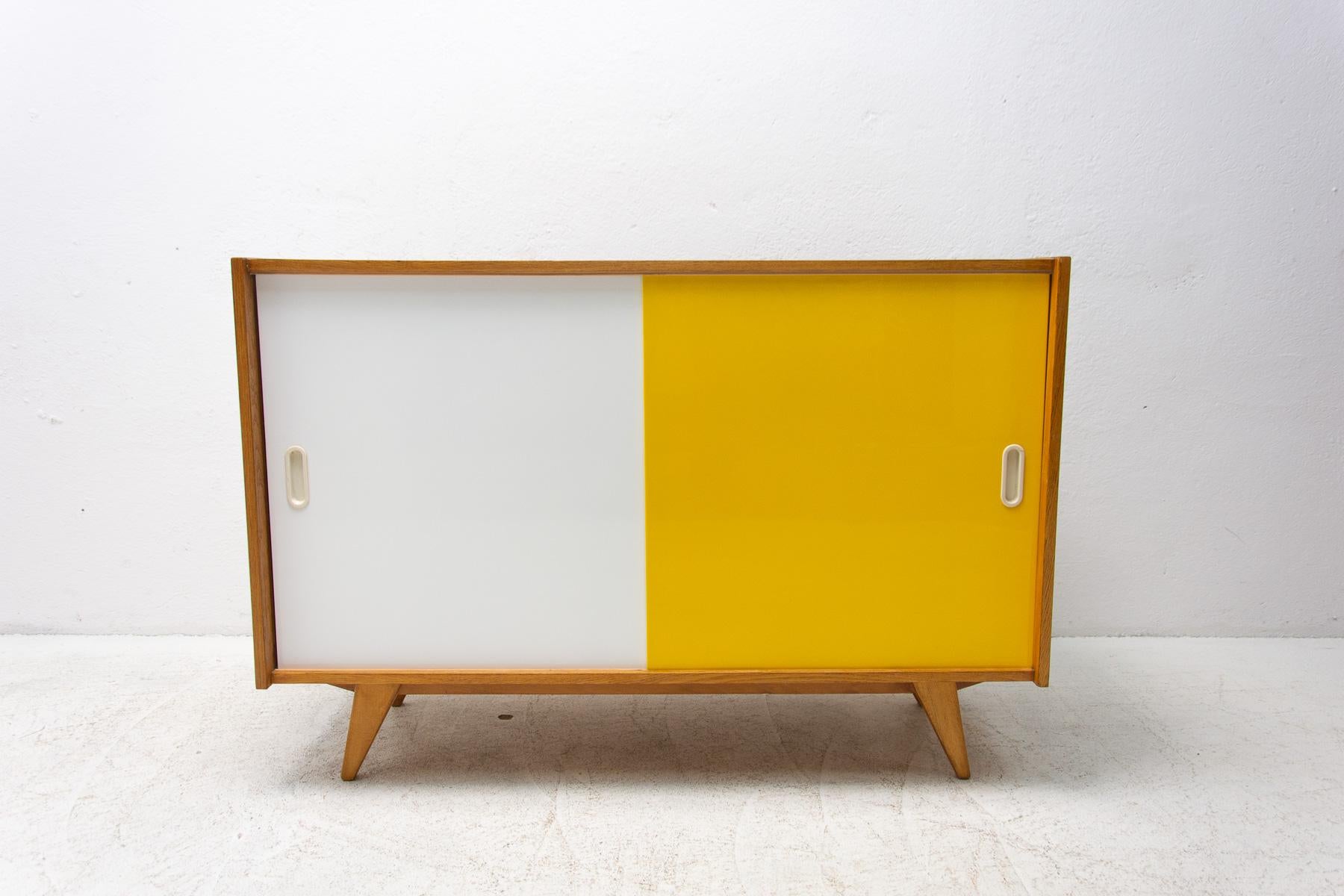 Midcentury sideboard-cabinet with sliding doors, catalogue No. U-452, designed by Jiri Jiroutek. It's made of beechwood, veneer, plywood and laminate. In excellent condition, fully refurbished.

The cabinet comes from the famous Universal series