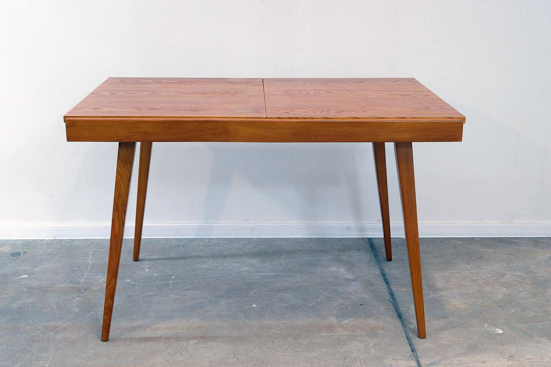 This midcentury adjustable dining table was designed by František Jirák for Tatra nábytok and made in the former Czechoslovakia in the 1970´s.  It´s made of ash and beech wood.  The lenght is adjustable from 120 cm to 180 cm. The table is in