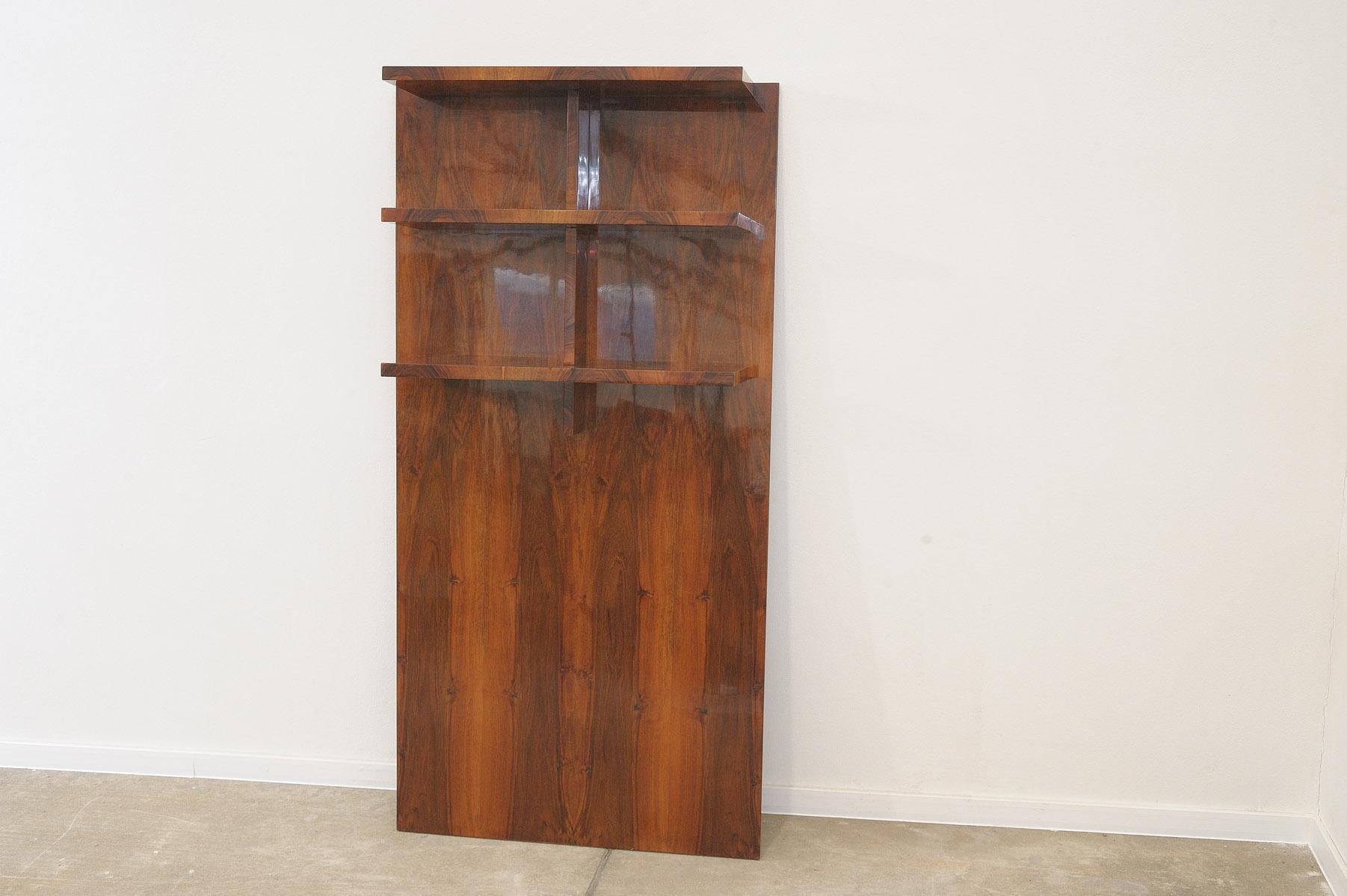 This  Wall shelf or bookcase was made in the former Czechoslovakia in the 1930s, It´s made of walnut, you hang it on the wall using two screws.

Dimensions of the shelves: 70x23x3cm between 1st and 2nd shelf is 27 cm, between 2nd and 3rd shelf is