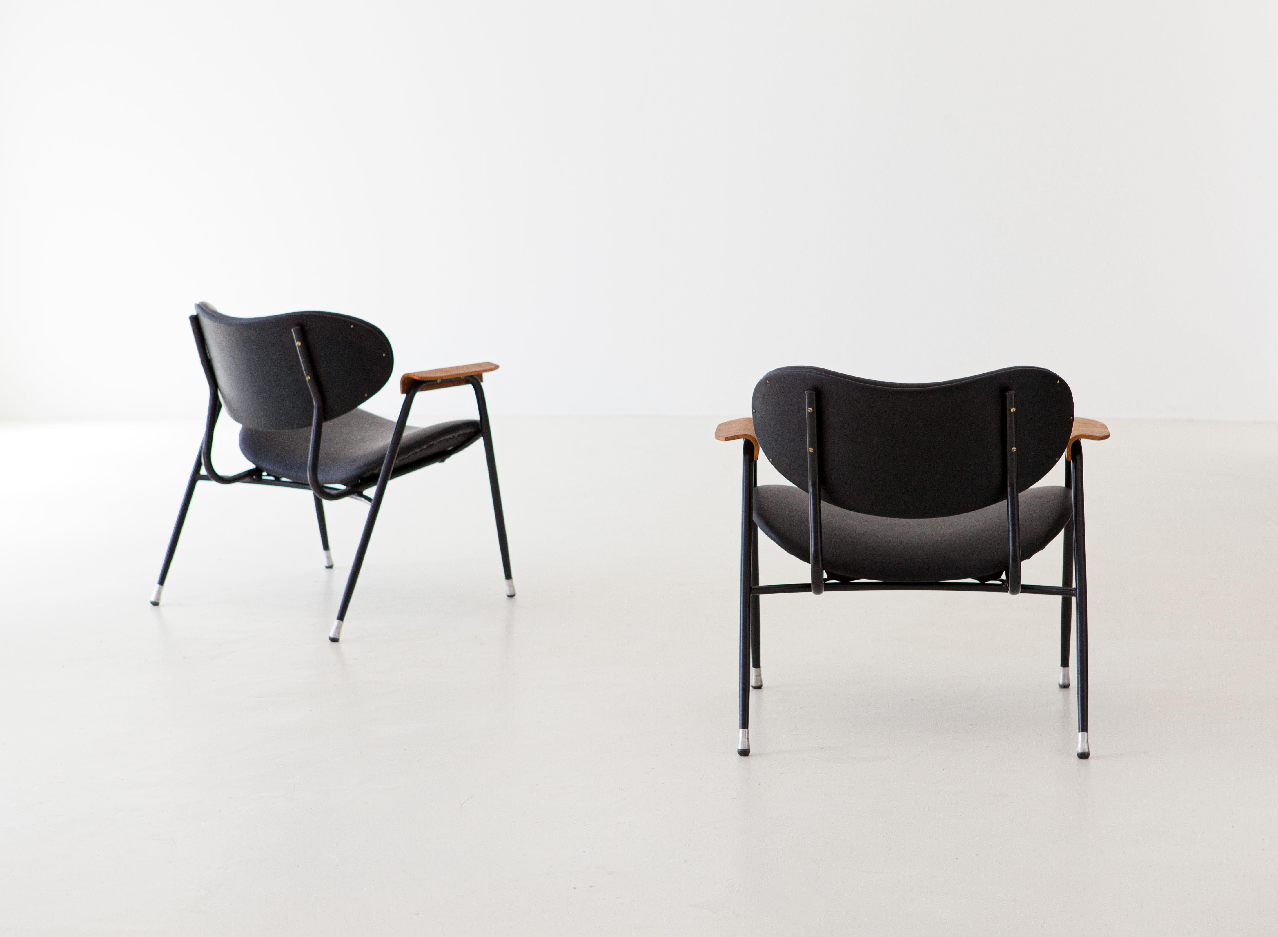 Set of two of Italian modern easy chairs with curved teak armrests, designed by Gastone Rinaldi and produced by RIMA during the 1950s. 

Completely restored: 
New black natural leather and new padding 
New black enamel on the iron frame
Sanding