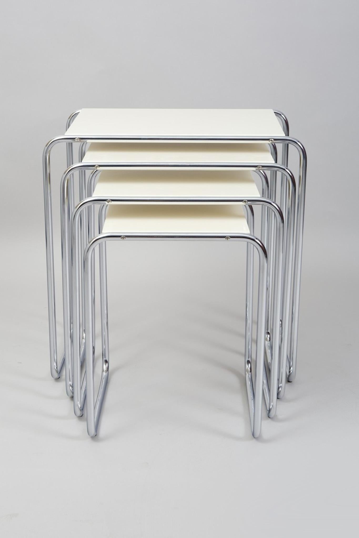 Beautiful White Nest tables made in the 1950s, they are made out of lacquered wood and chrome plated steel. 
Made by Kovona

Dimensions of the biggest piece: 
Height: 59 cm (23.23 in)
Width: 56,5 cm (22.24 in)
Depth: 37 cm (14.57 in).
 