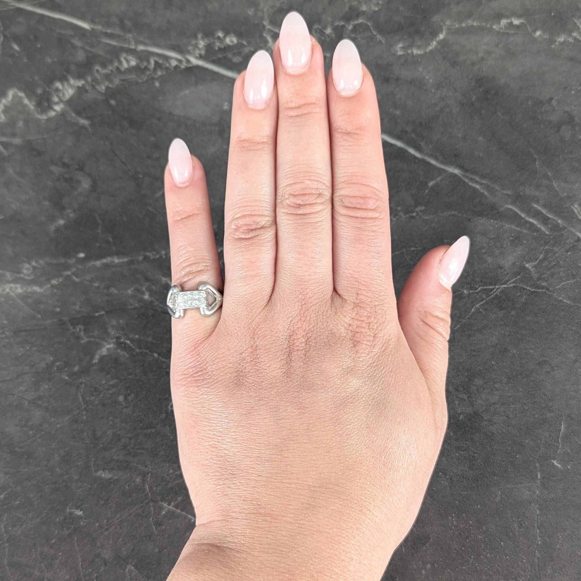 Centering two parallel rows of single cut diamonds channel set to front
Weighing approximately 0.30 carat total - G/H color with VS2 clarity
Flanked by pierced buckle motif shoulders
Accented by groove and milgrain detail
Inscribed 'H.M.D.