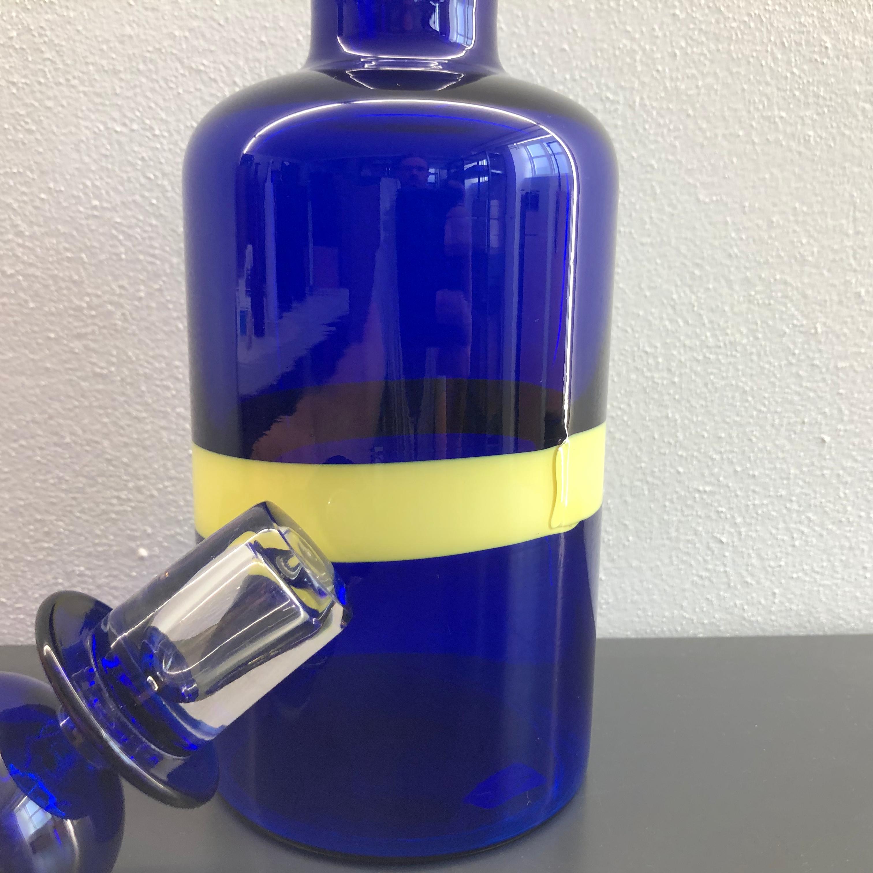 The decanter is decorated with a yellow robbin on the deep blue base, a classical 