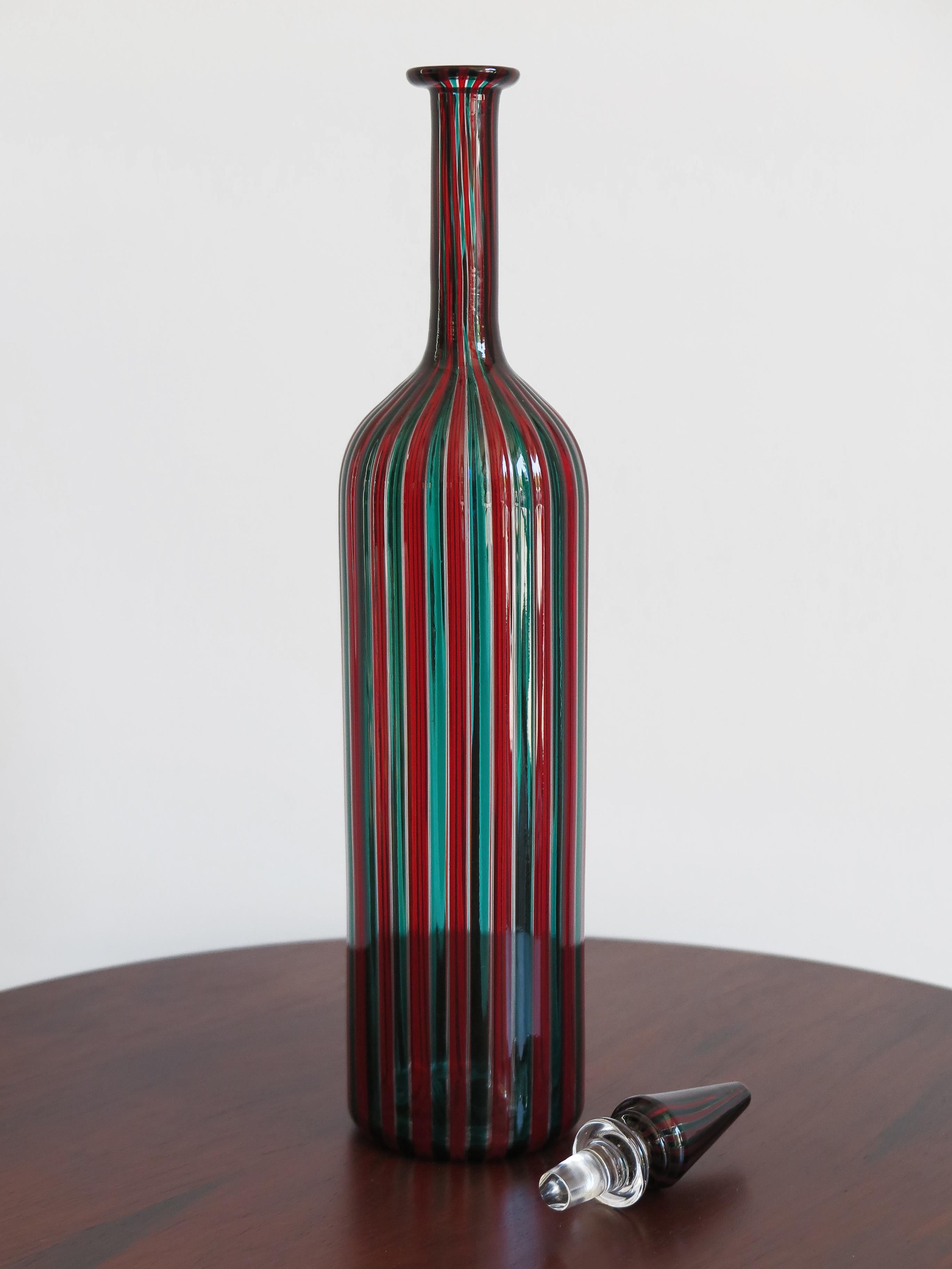 Italian famous bottle with blown glass stopper decorated with red and green canes designed by Fulvio Bianconi for Venini Murano in 1988, cone-shaped stopper, engraved signature under the base Venini 88.
Signature engraved under base Venini 88.