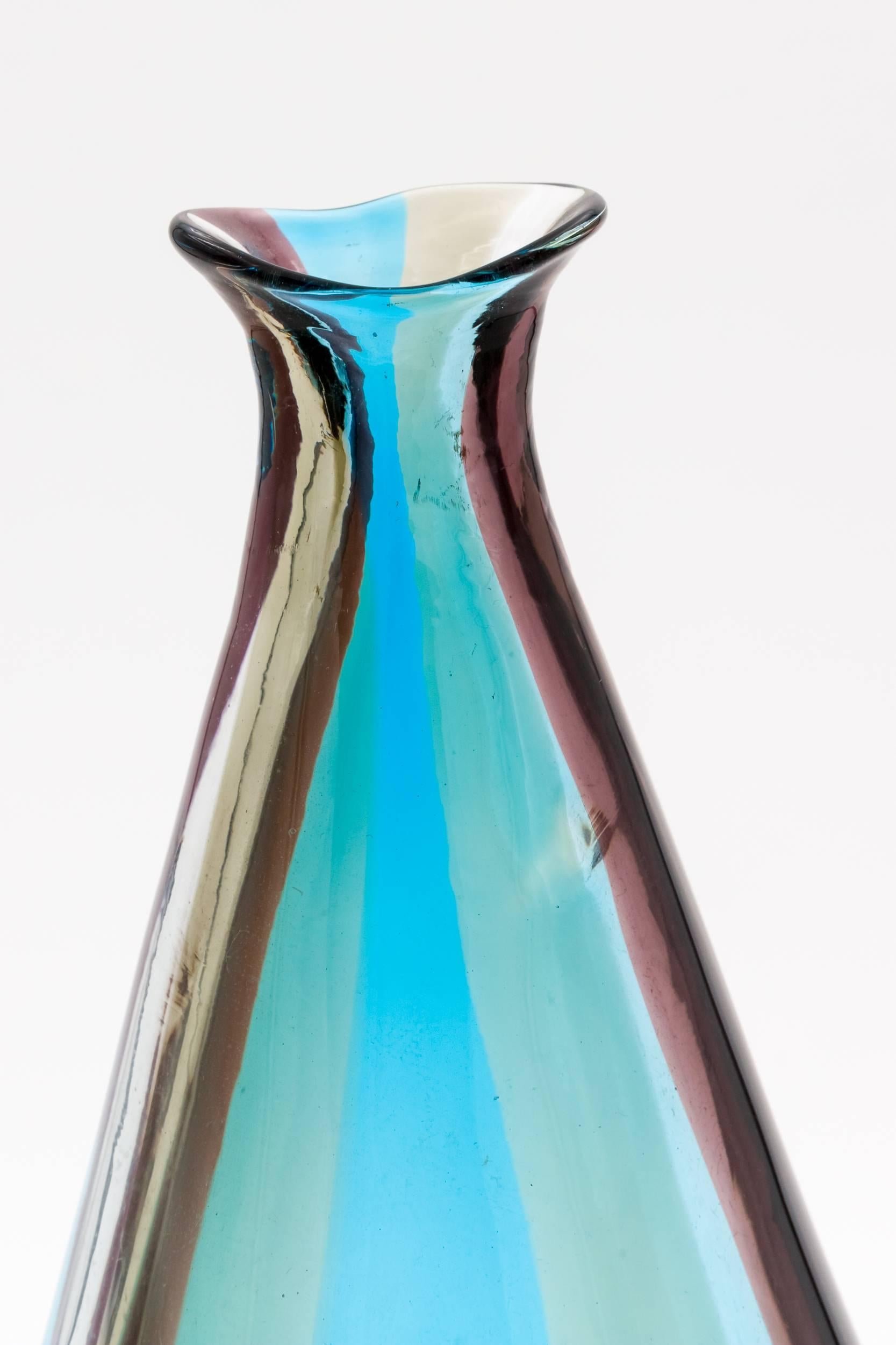 A large vase with an elongated neck of the spicchi serie with wide vertical wine-colored, cyclamen and acquamarine bands known as model 4891 designed 1953-1957.

This model was designed by Fulvio Bianconi when he was artistic director of Venini