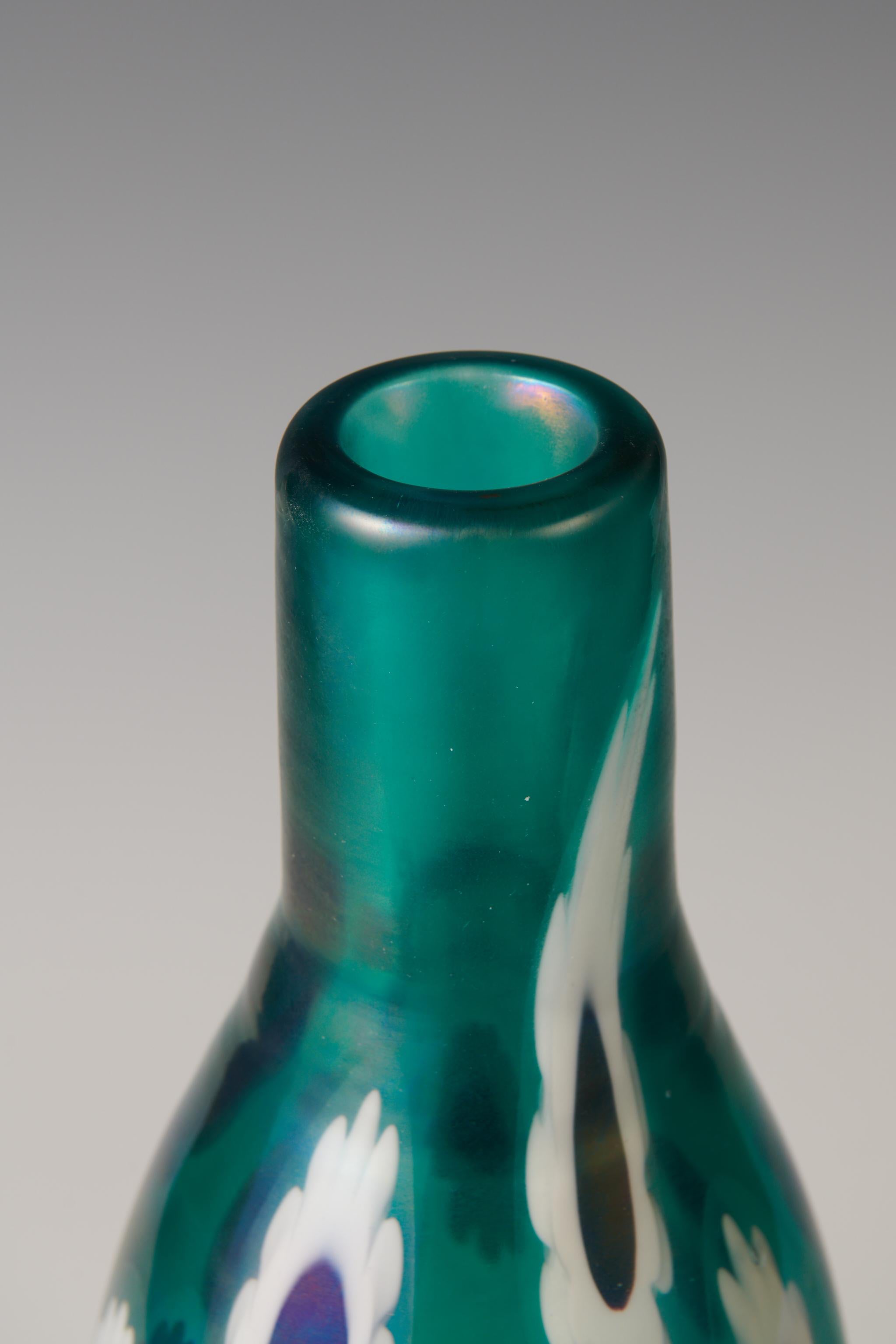 Fulvio Bianconi for Venini

Marghuerite vase

Venini Italy, 1951

glass with internal decoration. Vase in thick clear cristallo glass decorated with a daisy motif murrine of lattimo and amethyst glass. The vase is part of a very limited series