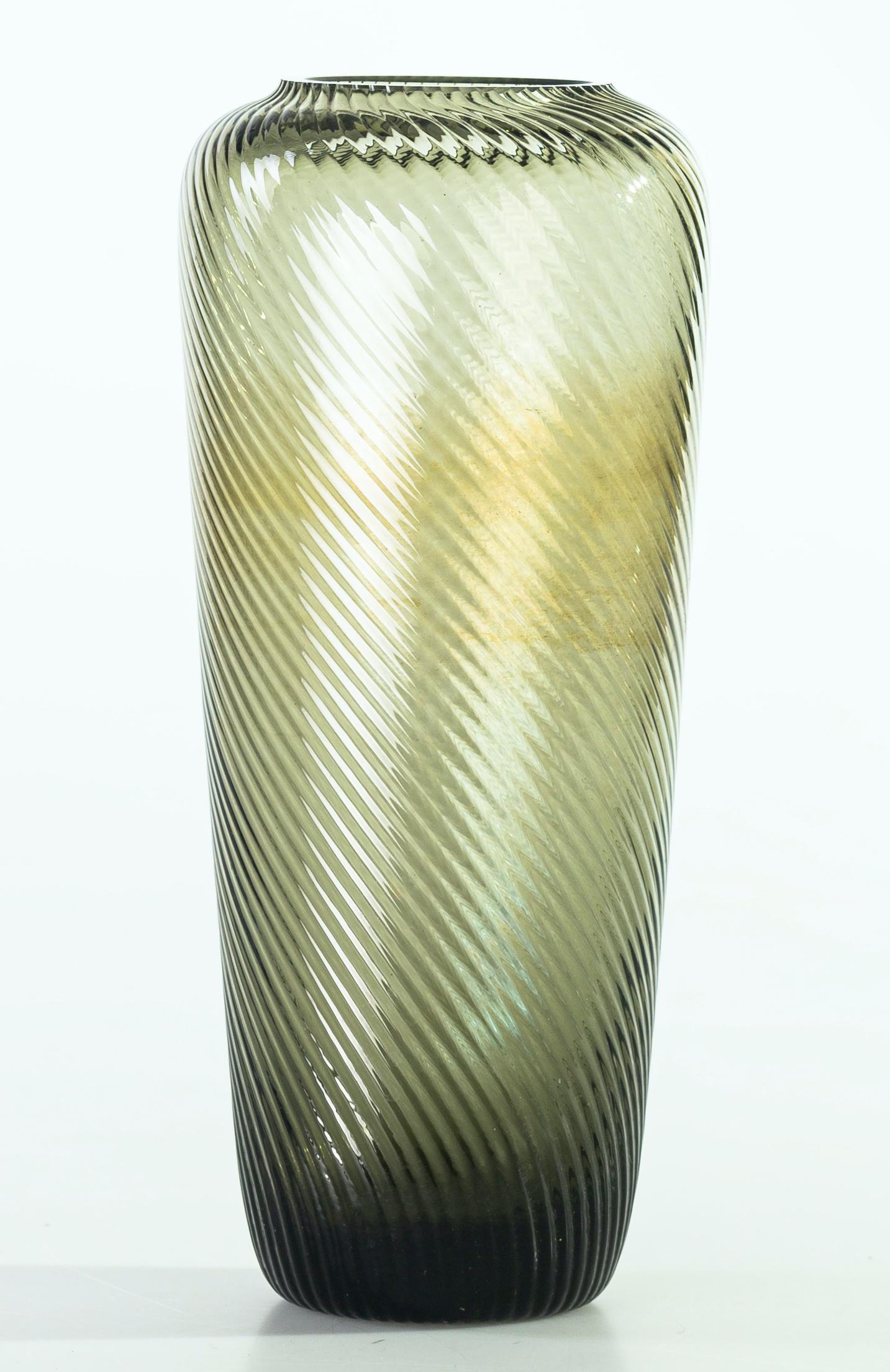This is a Fumé glass vase, a beautiful smoked glass vase decorated all-over the body with slightly raised helical ribs.

Made in Germany in the 1960s of the 20th century. 
In excellent conditions.