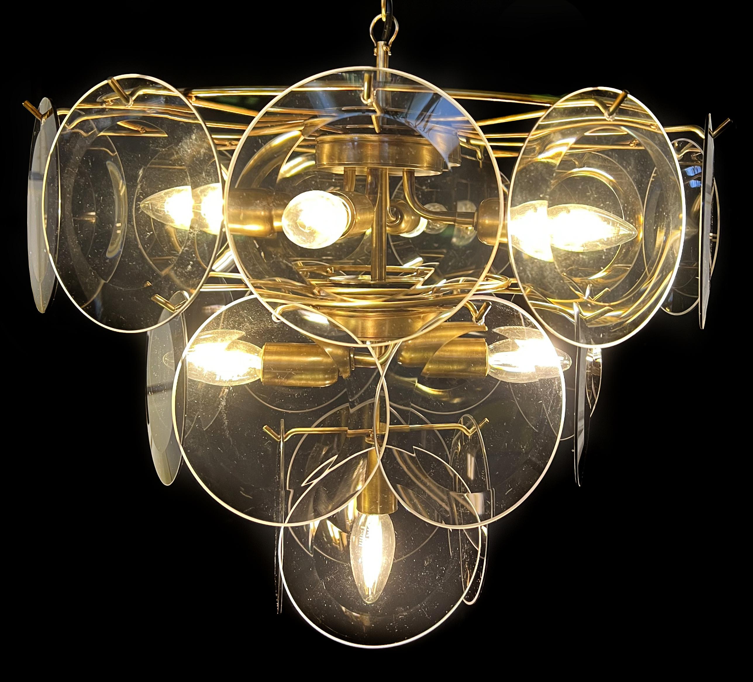 Vintage Italian Murano chandelier by Vistosi. The chandelier has 23 fantastic  fumé discs in a gold metal frame.
Period: late XX century
Dimensions: 44,50 inches (150 cm) height with chain; 19,40 inches (50 cm) height without chain; 19,40 inches (50