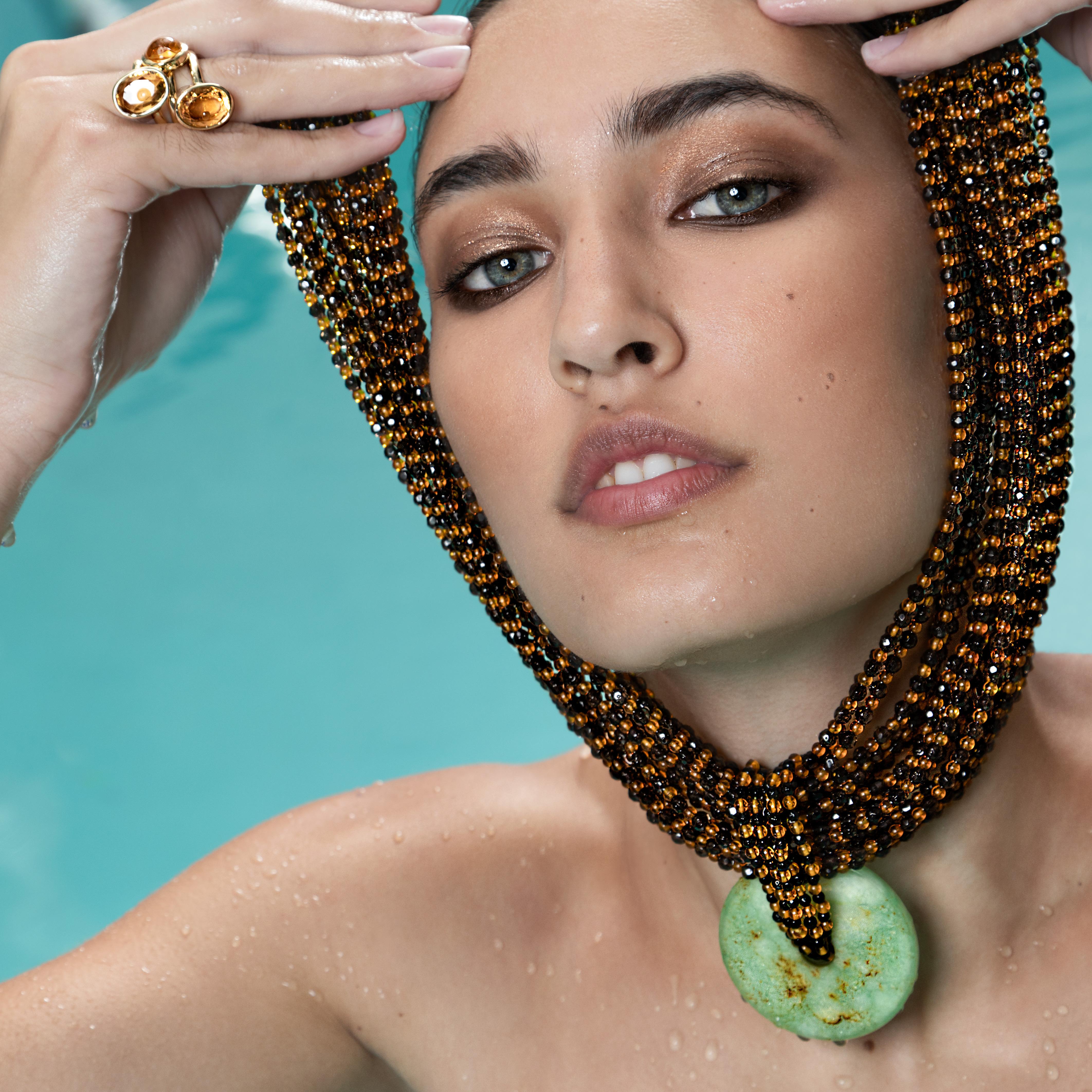 Splendida e suggestiva collana d'ambra fatta a mano con un ciondolo a forma di principessa nubiana in quarzo fumè e ambra.  Impreziosito da una ciambella di giada centrale rotonda unica nel suo genere.

Questo design si ispira alle foreste