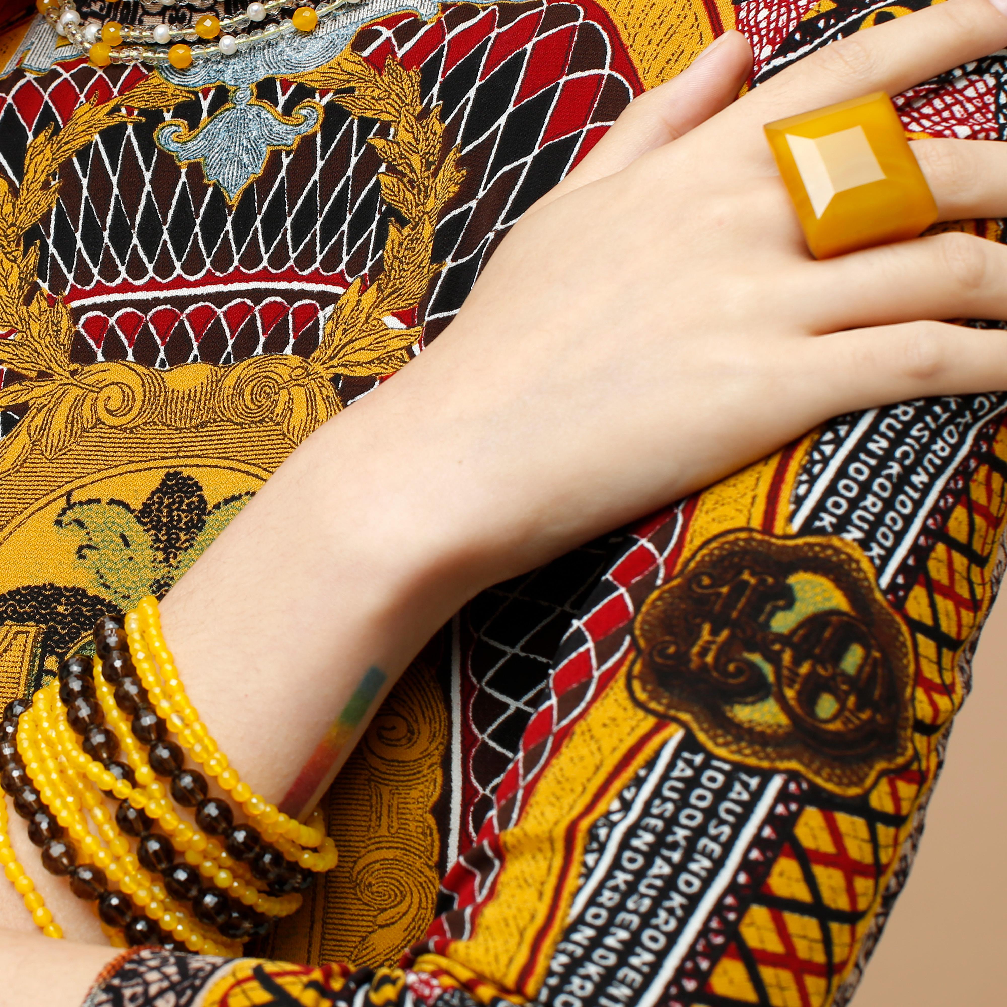 Deléitate con un luminoso conjunto de joyas artesanales de ágata amarilla. Una moderna pulsera de cuentas redondas de cuarzo fumè facetado y ágata con un impresionante y cómodo anillo princesa rígido de ágata amarilla. El complemento perfecto para