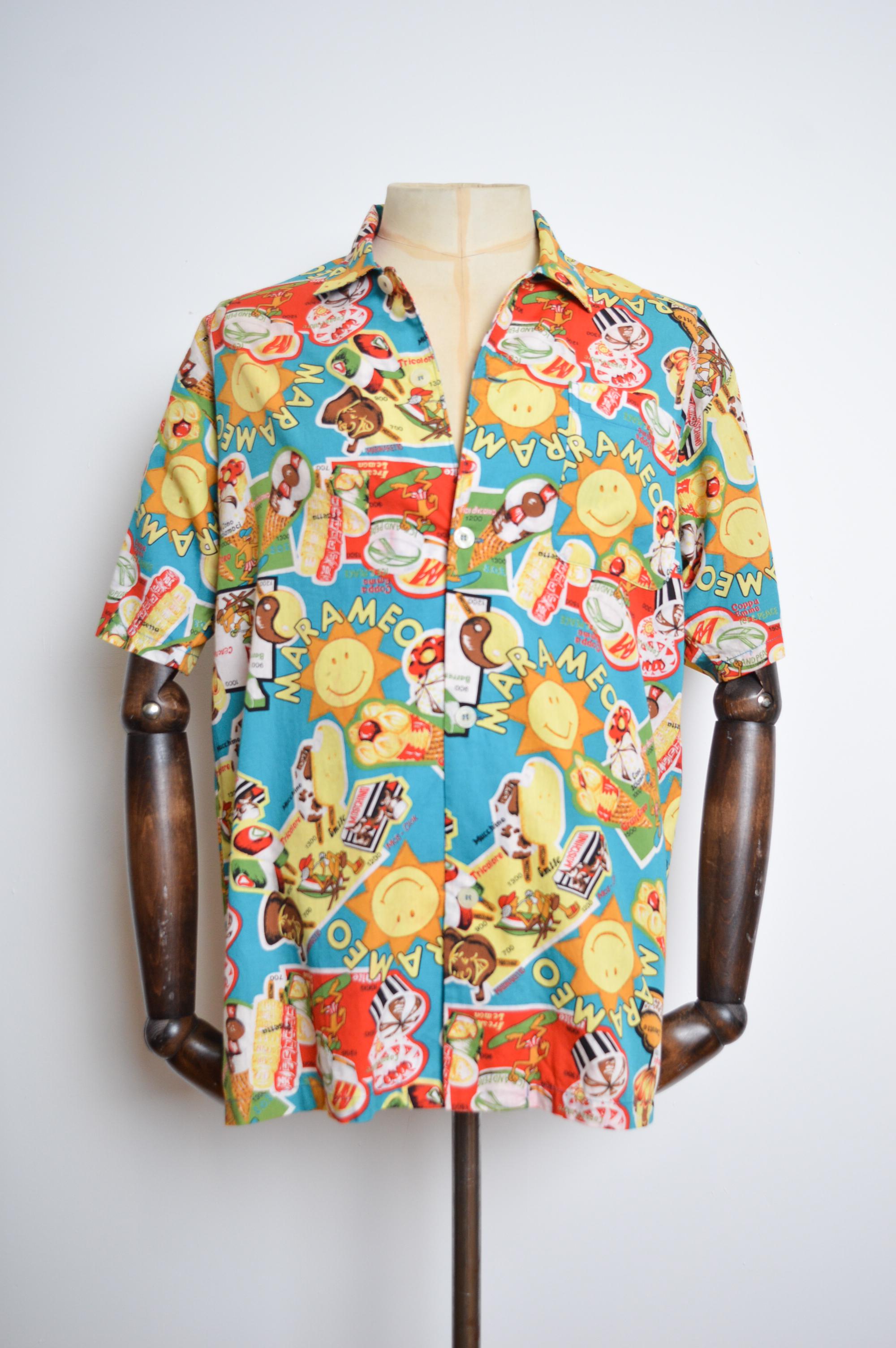 1990's Vintage 'MOSCHINO' Hemd mit Eiscreme-Muster und kurzen Ärmeln, gefertigt aus farbenfroh bedruckter Baumwolle. Perfekt für die Summer Raves.

GEFERTIGT IN JAPAN.  
Eigenschaften: Knöpfe auf der Vorderseite, Kragen, kurze Ärmel, Brusttasche,