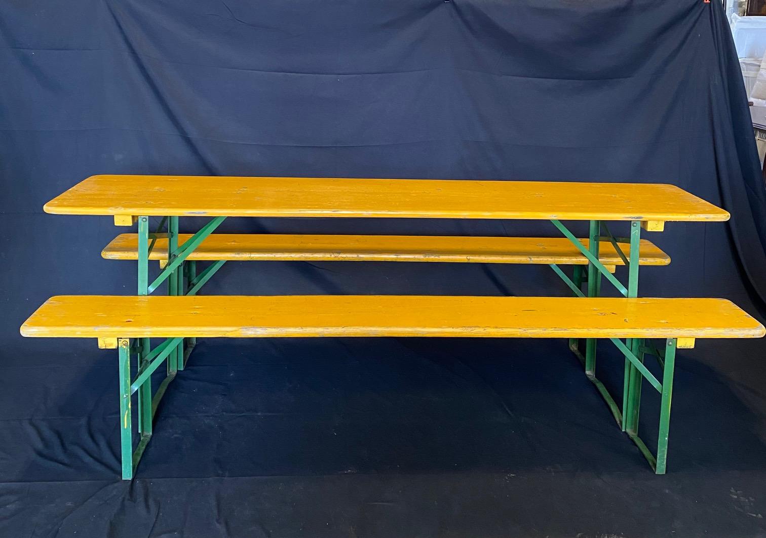 Vintage collapsible German beer garden table and bench set, consisting of a folding table and two folding benches with original paint. Great size and color, very sturdy, show signs of use and wear, patina. Structurally sound, mechanics function
