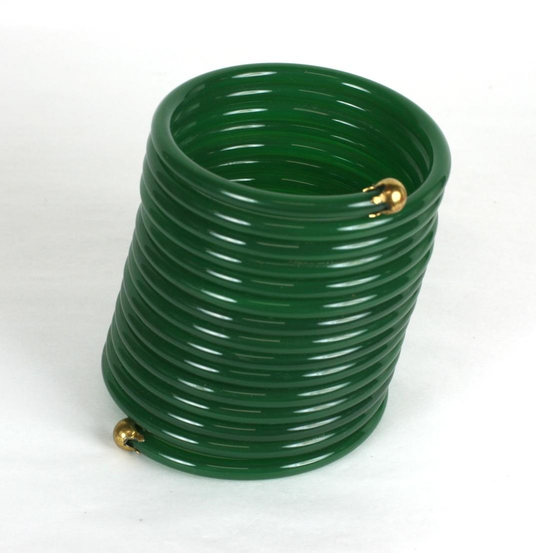 Lustiges Slinky-Armband aus gesponnenem Nylon aus den 1960er Jahren. Jadegrüner Kunststoff mit Kugelanschlüssen aus Messing. Gesponnenes Nylon dehnt sich wie Slinky. 
1960er Jahre USA.  
3,5