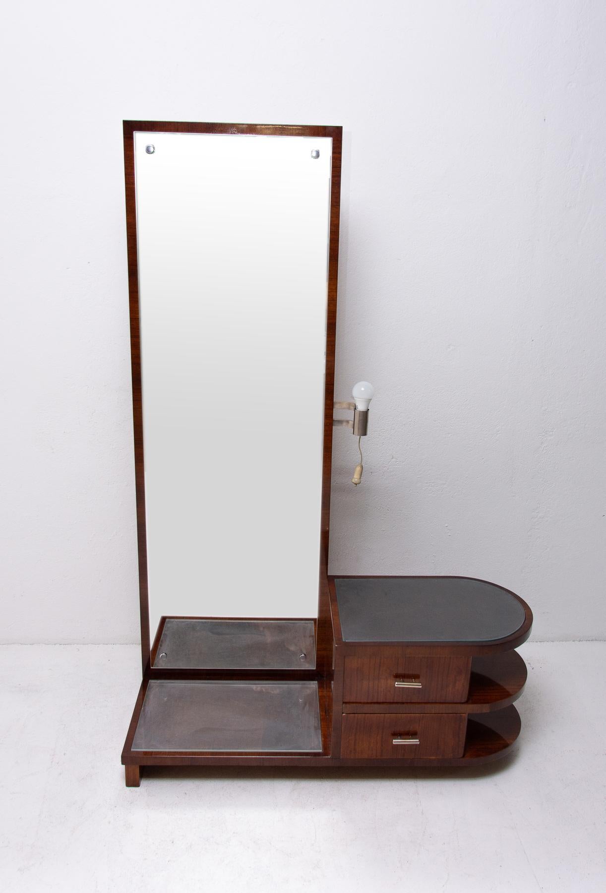 Functionalist vanity/dressing table-mirror with a drawers for toiletries. It was designed by Czech pre-war architect Vlastimil Brožek and it´s made of wood with walnut veneer. The mirror is equipped with a storage spaces at the bottom, it features a